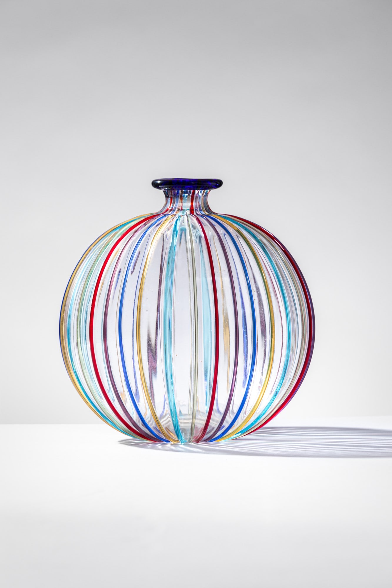 Lino Tagliapietra. Vaso della serie Rainbow: Vaso della serie Rainbow Vetro soffiato cristallo con decoro di canne policrome a rilievo. Effetre International, 1985 ca. Firma incisa a punta Effetre International Murano. Etichetta parziale del pro