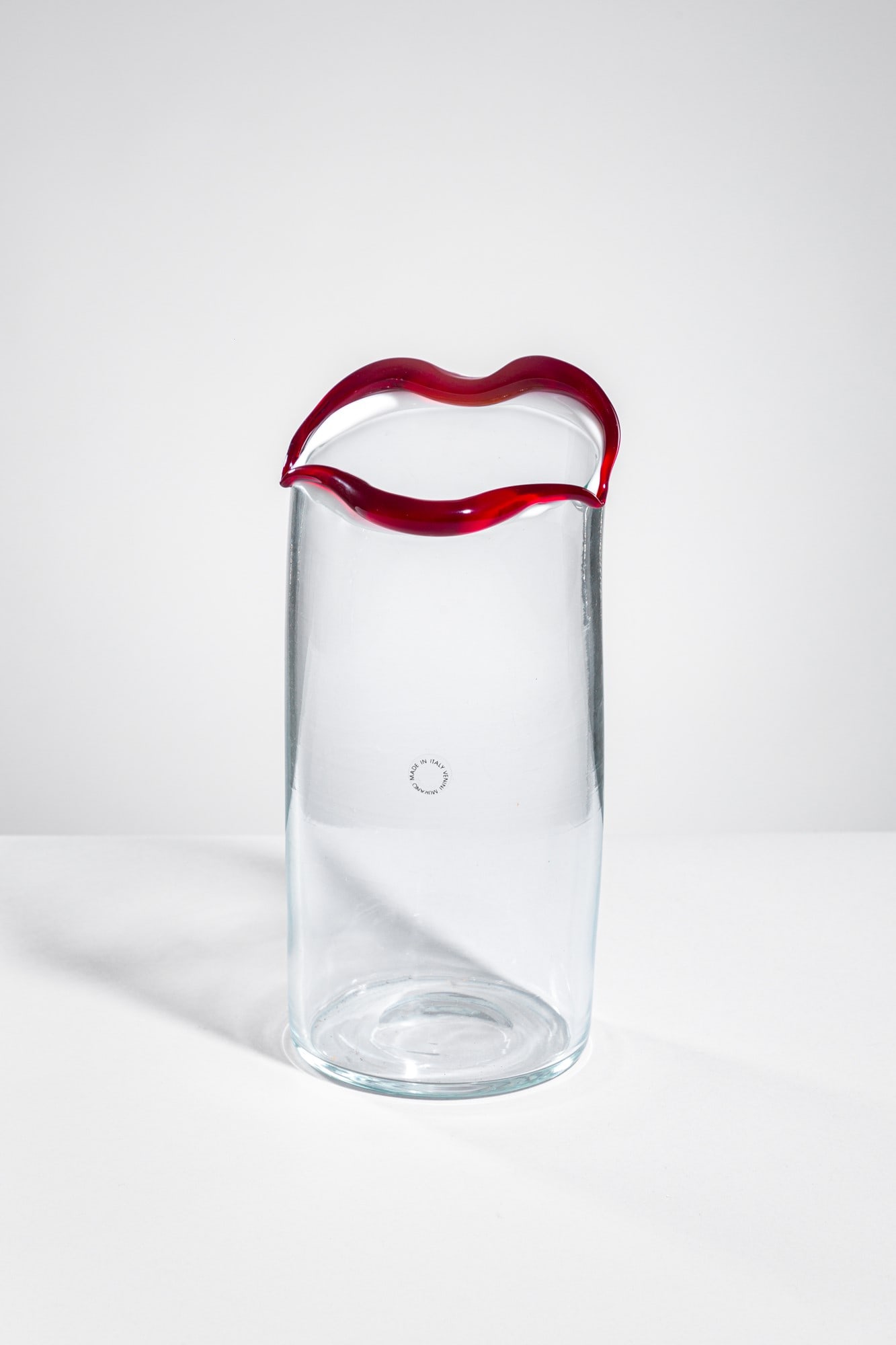 Fulvio Bianconi. Vaso della serie Sorriso: Vaso della serie Sorriso Vetro cristallo con orlo rifinito in lattimo e rosso modellato a forma di bocca. Venini, 1993 Firma incisa a punta Venini '93 Fulvio Bianconi. Etichetta Venini Murano made in