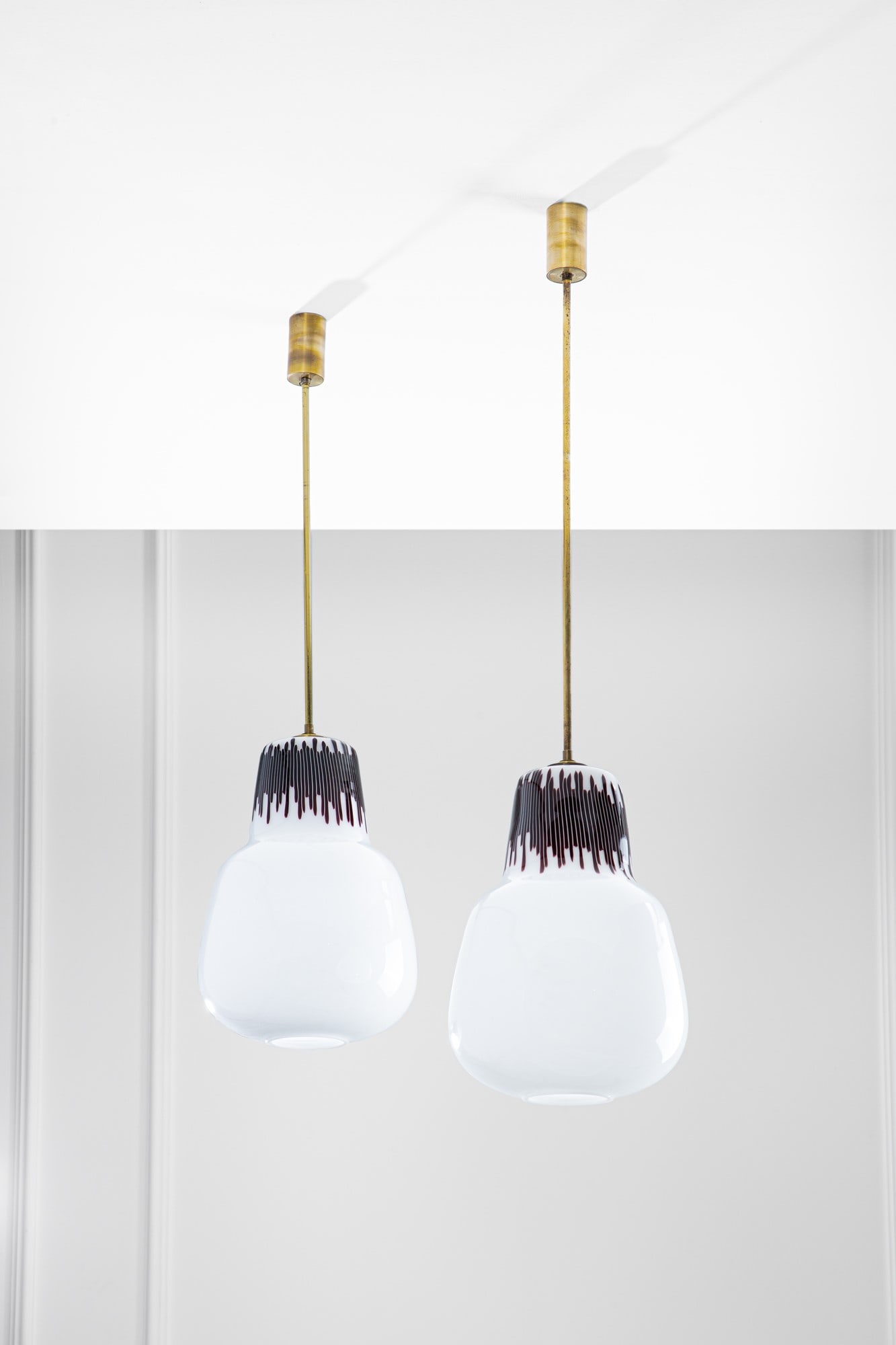 Massimo Vignelli. Due lampade a sospensione mod. 4037: Due lampade a sospensione mod. 4037Vetro opalino con tratto superiore tronco-conico a canne verticali ametista scuro.Prod. Venini, 1954-1955.h cm 96, diam. cm 26, h cm 108, diam. cm 26BIBLIOGRAFIA: