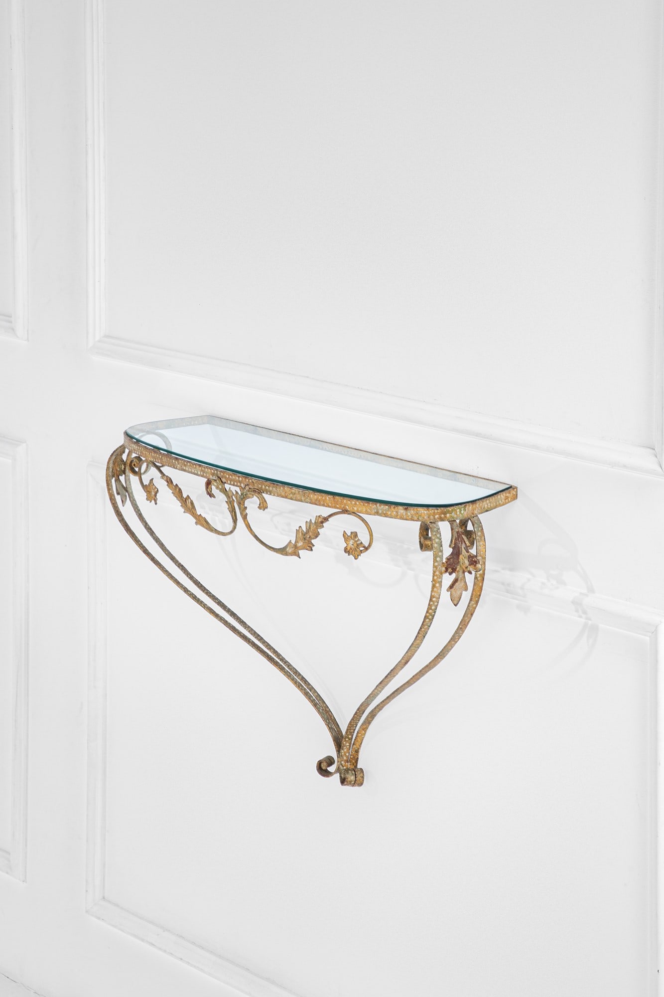 Pier Luigi Colli. Console pensile: Console pensileMetallo dorato martellato e forgiato a motivi vegetali, vetro molato.Prod. Colli, 1950 ca.cm 56x86x26