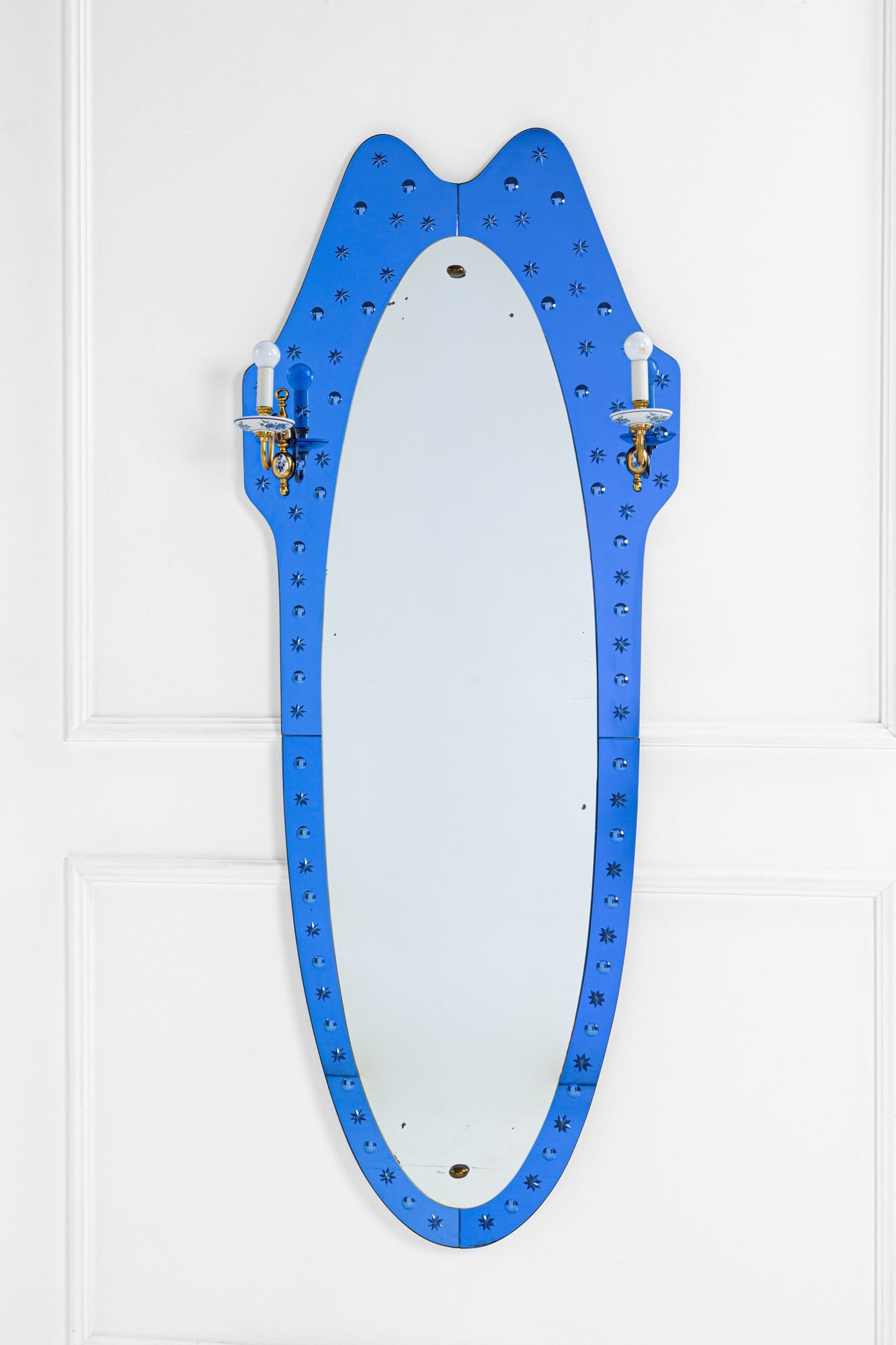 Cristal Art. Specchiera mod. 2843 con appliques: Specchiera mod. 2843 con appliquesCristallo colorato decorato a sfere e stelle, vetro specchiato, ottone, porcellana decorata.Prod. Cristal Art, 1950 ca.cm 184x72x21BIBLIOGRAFIA: D. Alaimo, Cristal