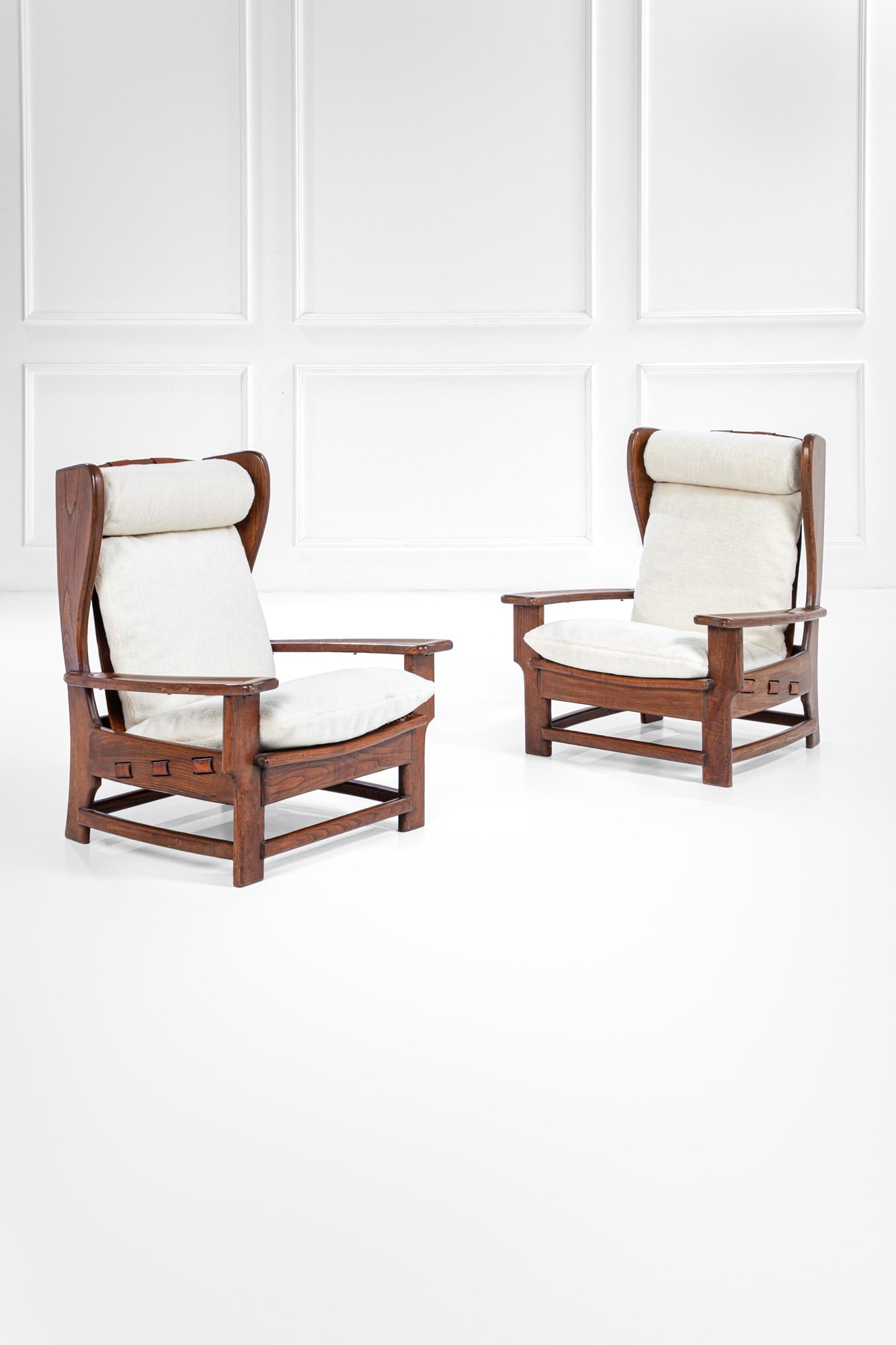 Due poltrone: Due poltrone Legno massello sagomato, cuoio, tessuto. Brasile, 1970 ca. cm 95x81x75