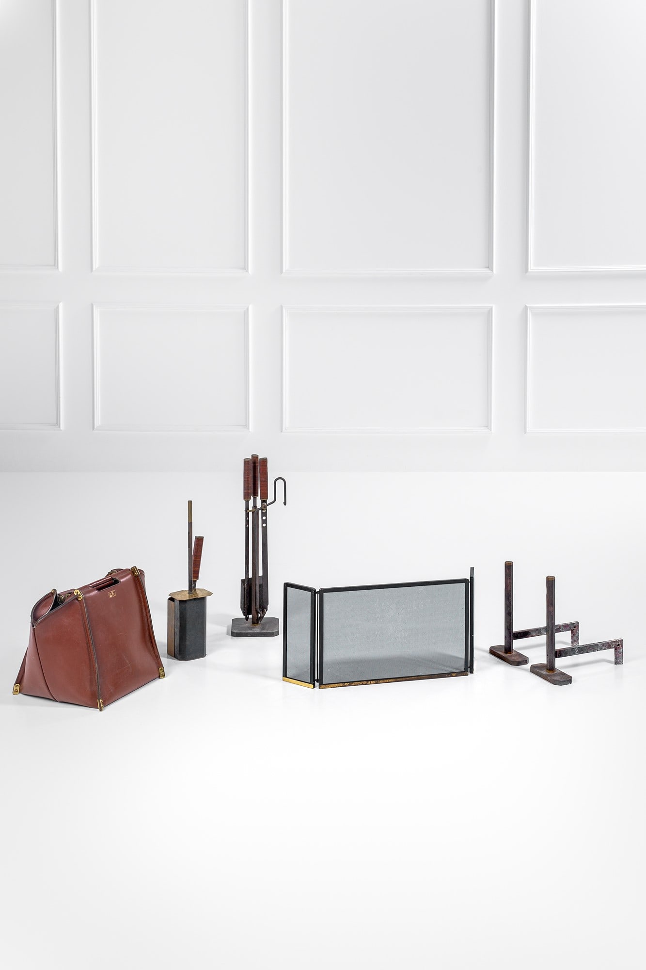 Afra e Tobia Scarpa. Set da camino: Set da camino composto da: parascintille, alari, attrezzi con portattrezzi e sacca portalegna.Ferro, ottone, legno, cuoio.Prod. Dimensione Fuoco, 1983 ca.Marchio del produttore.Parascintille cm