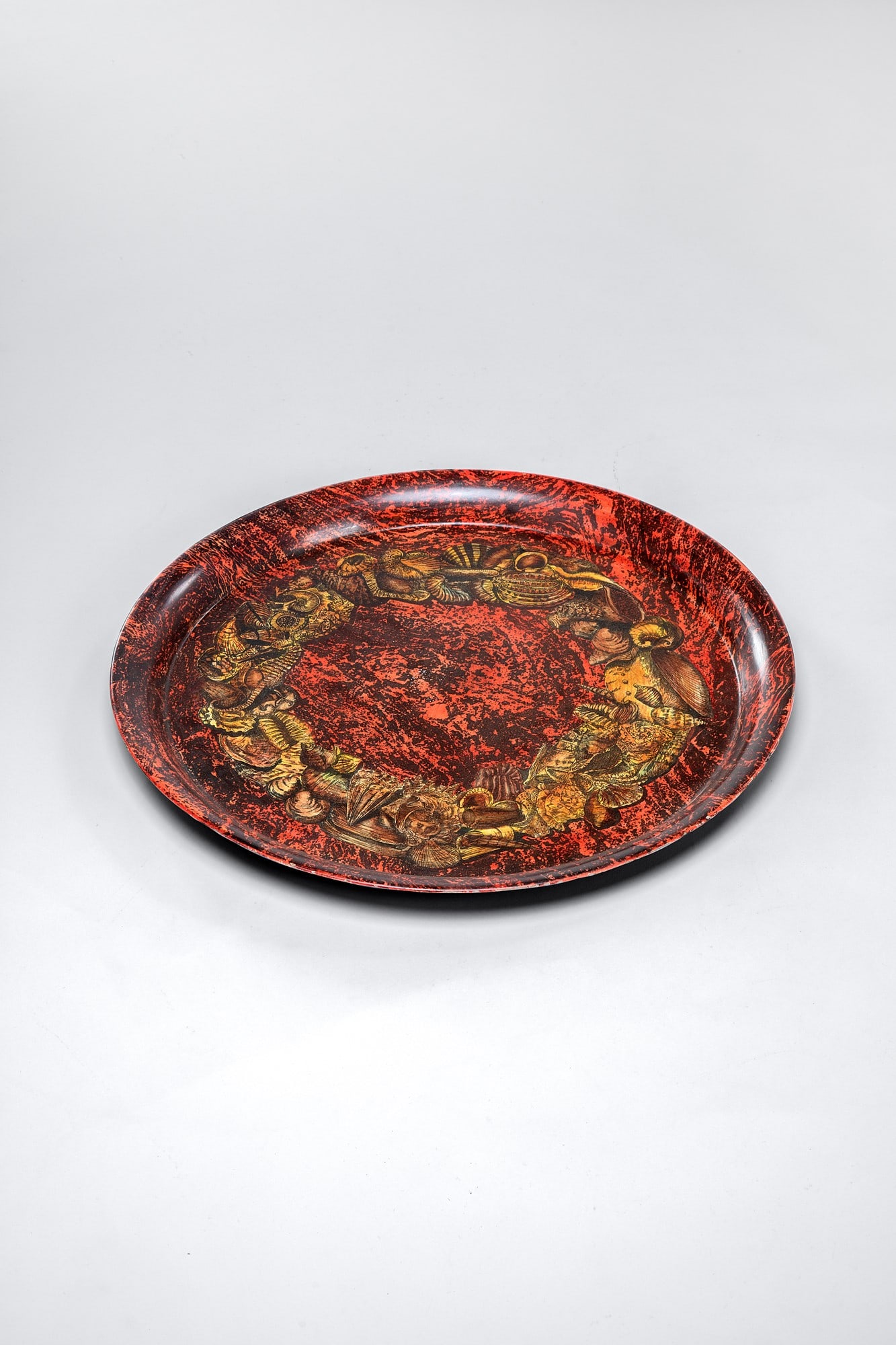 Piero Fornasetti. Vassoio decoro Fossili: Vassoio decoro FossiliMetallo serigrafato.Prod. Fornasetti, Etichetta del produttore.diam. cm 60BIBLIOGRAFIA: Mariuccia Casadio, Barnaba Fornasetti, Fornasetti. L'artista alchimista. La bottega