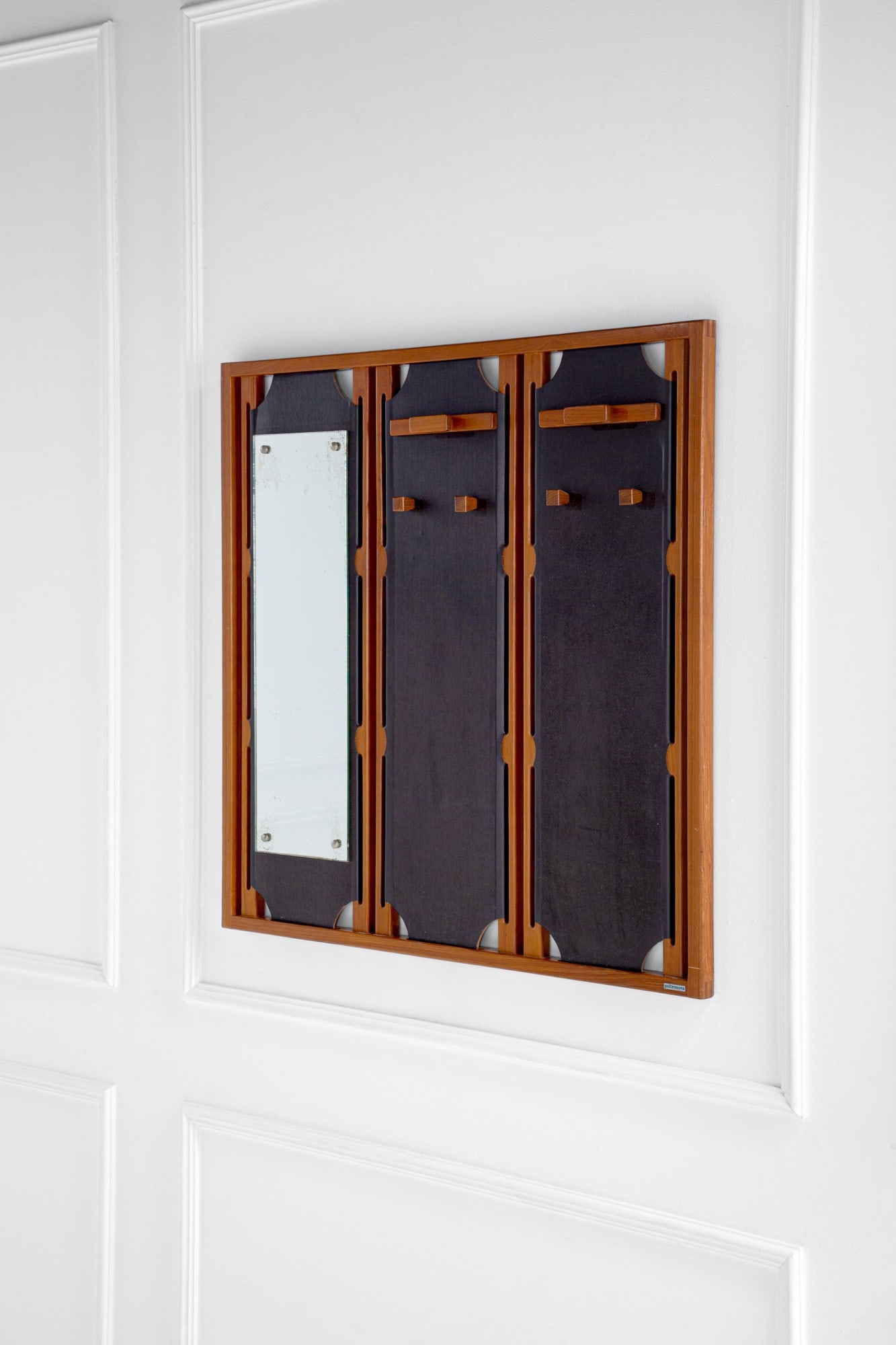 Poltronova. Attaccapanni da parete con specchiera: Attaccapanni da parete con specchiera Legno, cuoio, vetro specchiato, metallo. Prod. Poltronova, 1970 ca. Etichetta del produttore. cm 110x110x8