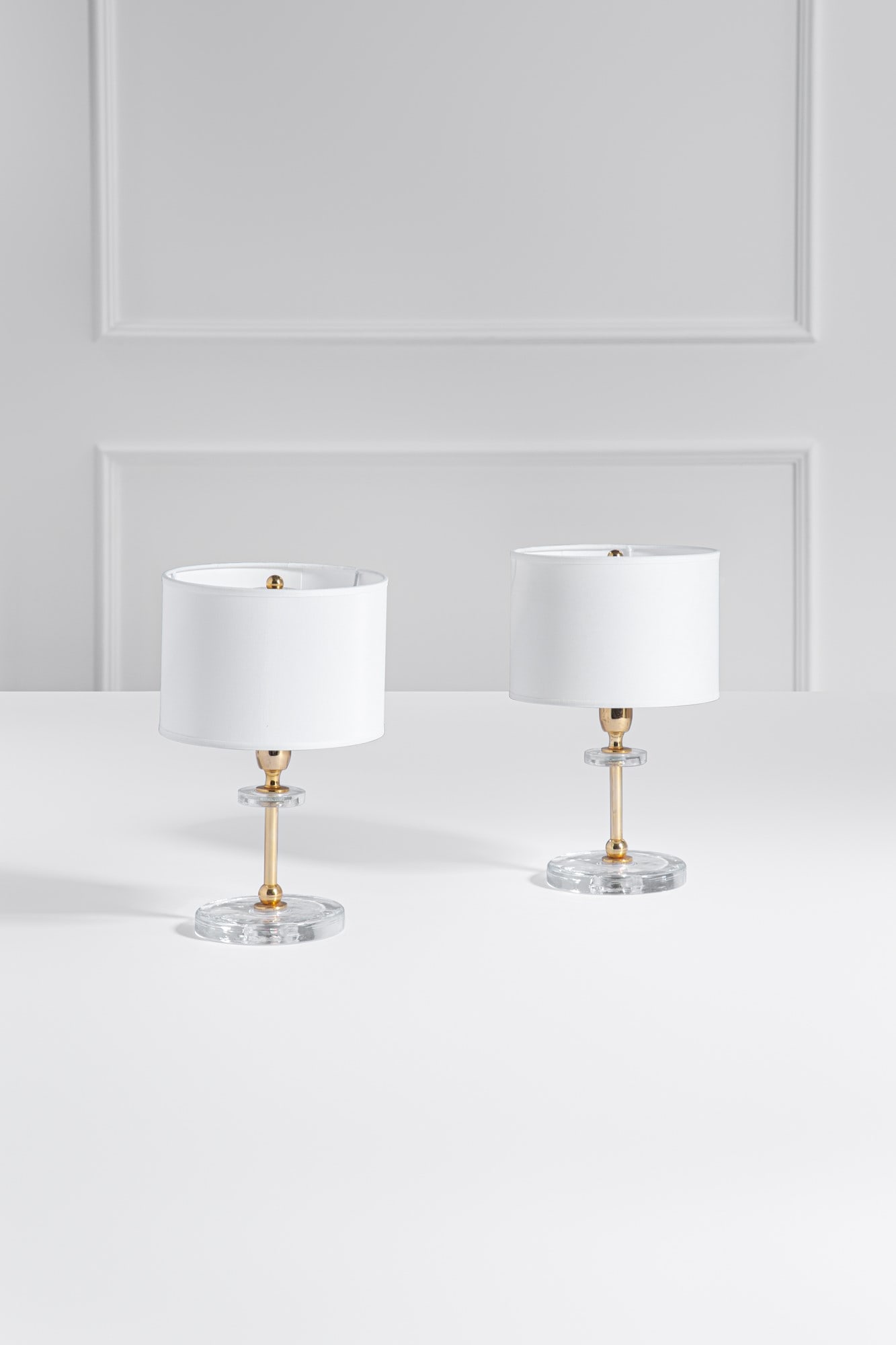 Due lampade da comodino: Due lampade da comodino Metallo dorato, vetro trasparente, tessuto. 1970 ca. h cm 32, diam. cm 20