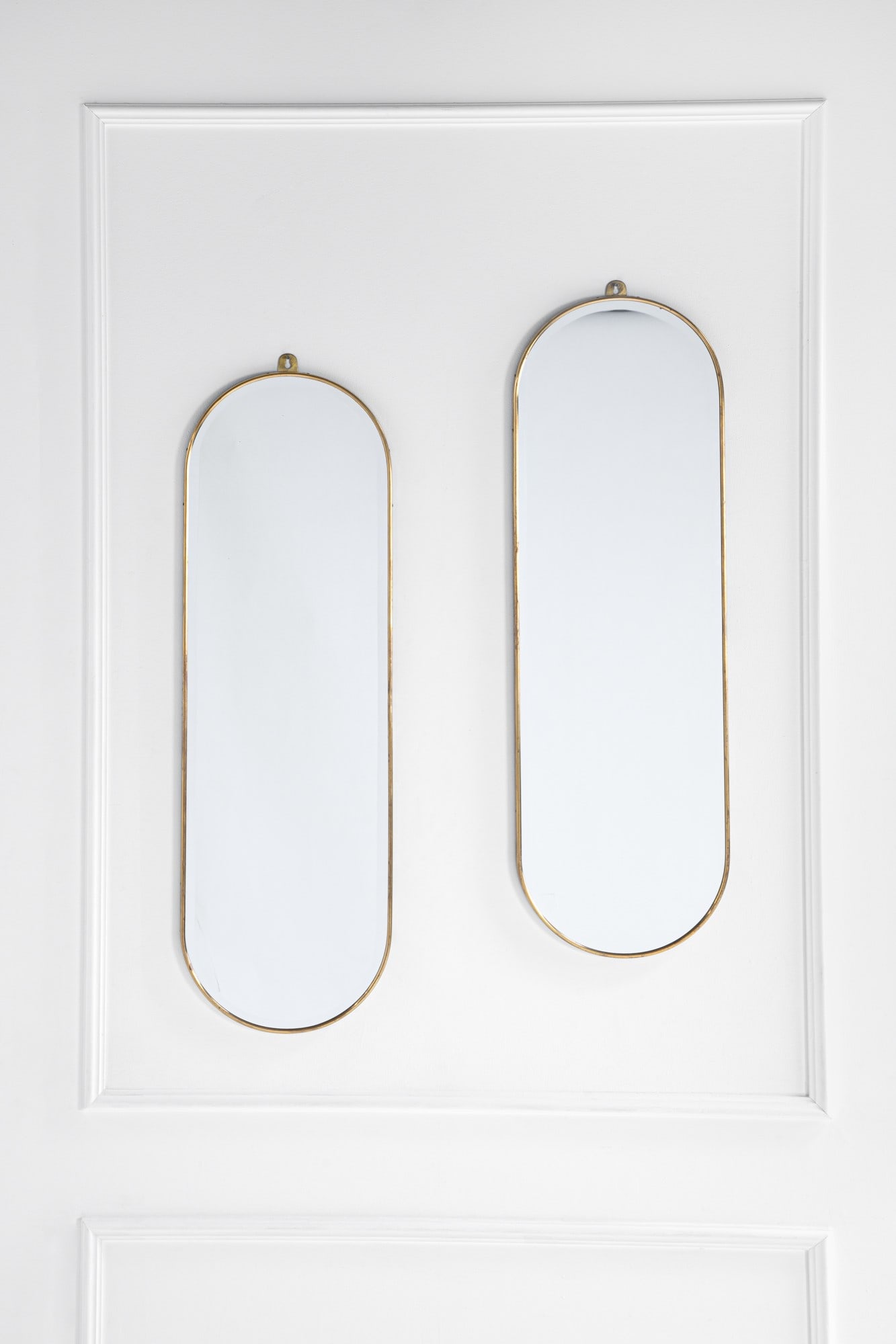 Due specchiere: Due specchiere ottone lucido, vetro specchiato molato. 1970 ca. cm 128x40x2