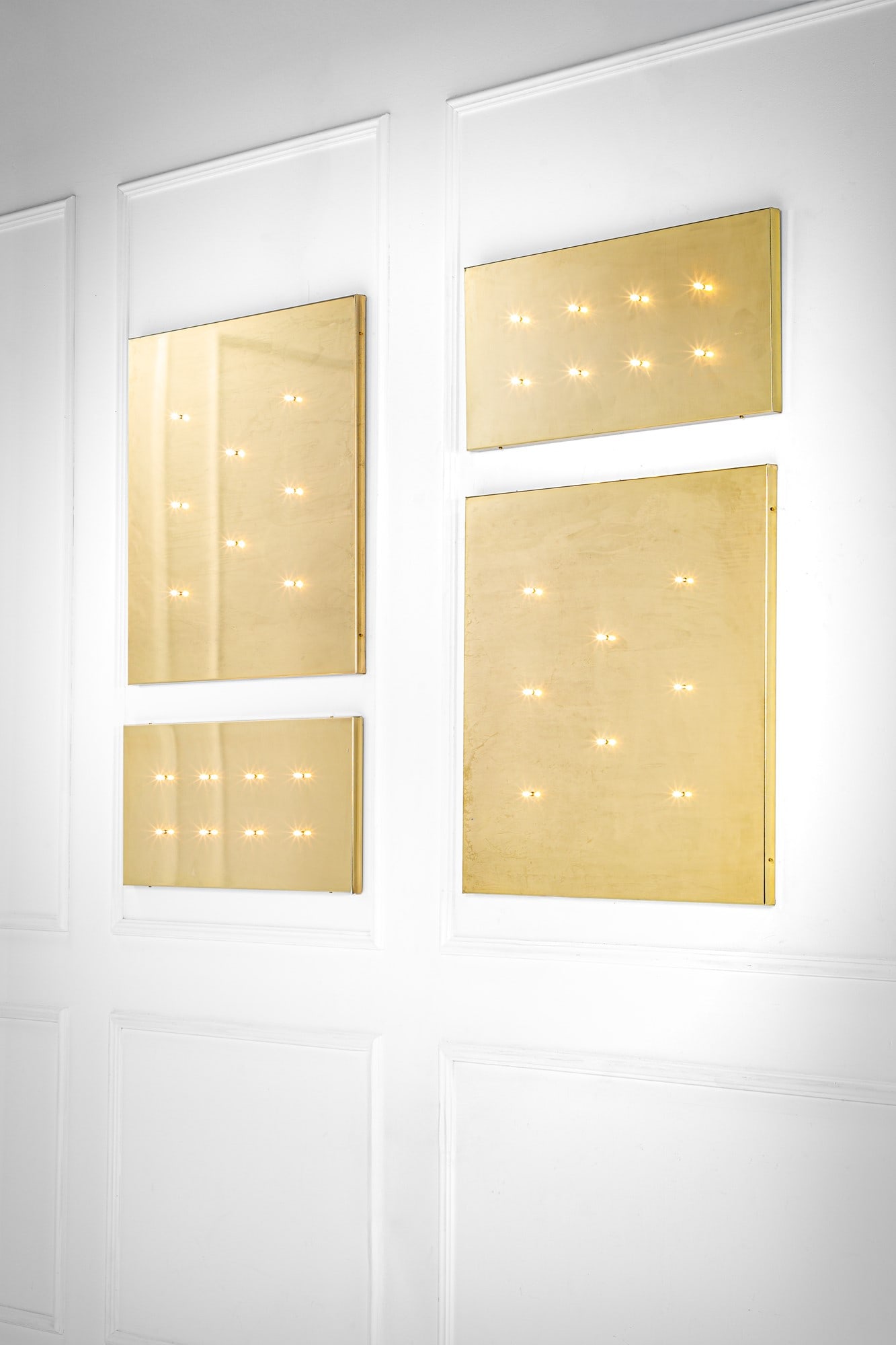 Stefano Adriani. Quattro pannelli luminosi: Quattro pannelli luminosiMetallo con finitura ottone.1990 ca.cm 41x90x3, cm 89x89x3