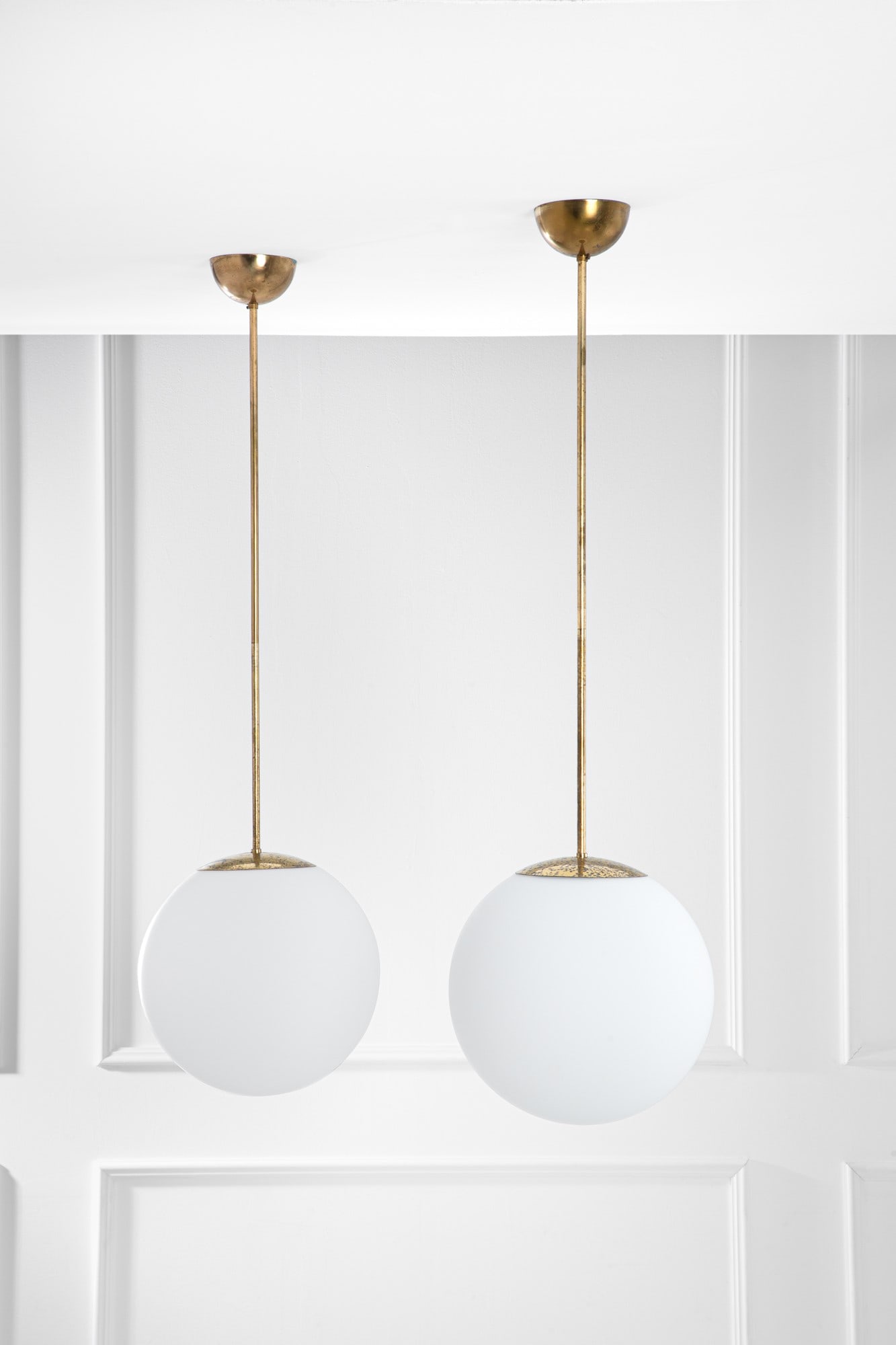 Due lampade a sospensione: Due lampade a sospensione Ottone, vetro opalino. 1950 ca. h cm 133, diam. cm 38