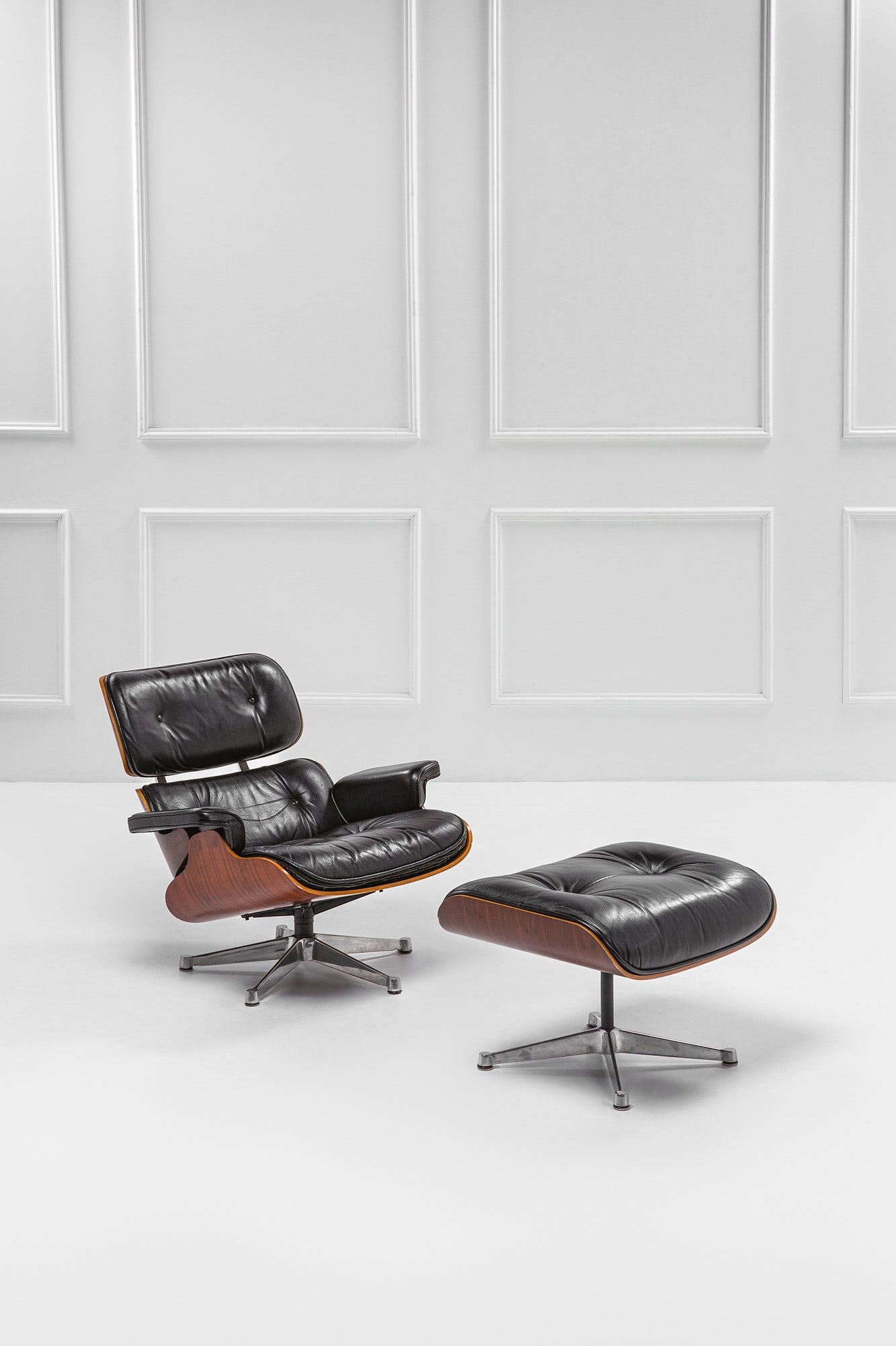 Charles e Ray Eames. Poltrona mod. 670 e poggiapiedi mod. 671: Poltrona mod. 670 e poggiapiedi mod. 671Alluminio pressofuso, compensato curvato impiallacciato, pelle.Progetto del 1956, edizione ICF 1970 ca.Etichetta del produttore.Poltrona cm 78x83x86,