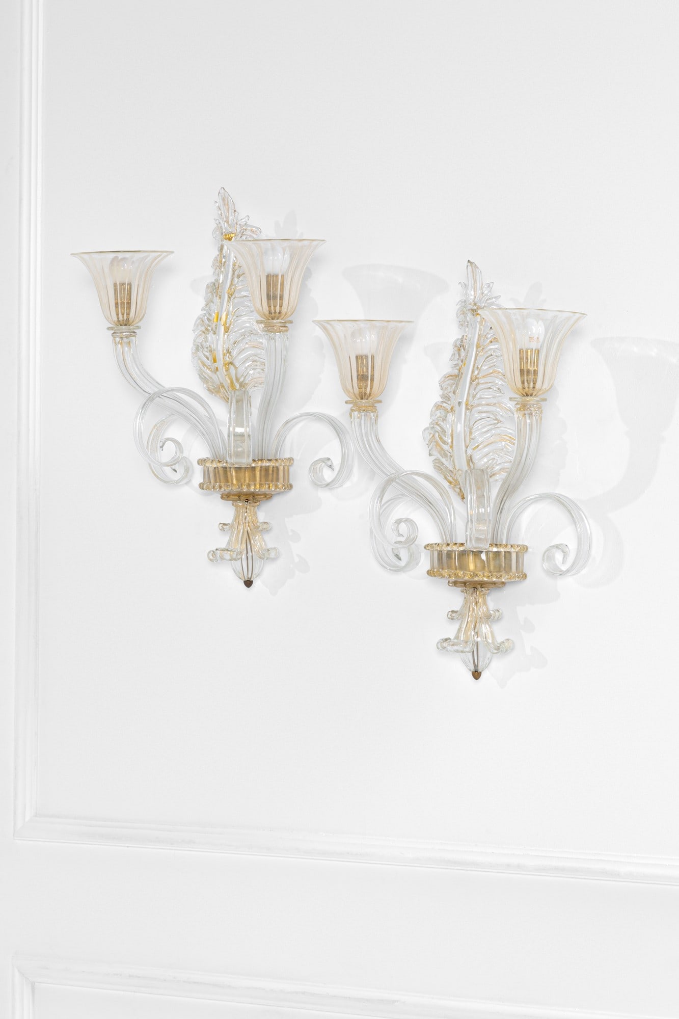 Barovier & Toso. Due lampade da parete: Due lampade da pareteElementi in vetro di Murano a motivi vegetali, vetro trasparente con inclusioni d'oro, ottone.Prod. Barovier & Toso, 1940 ca.Provenienti dall'Hotel Gallia di Roma.cm 63x37x22