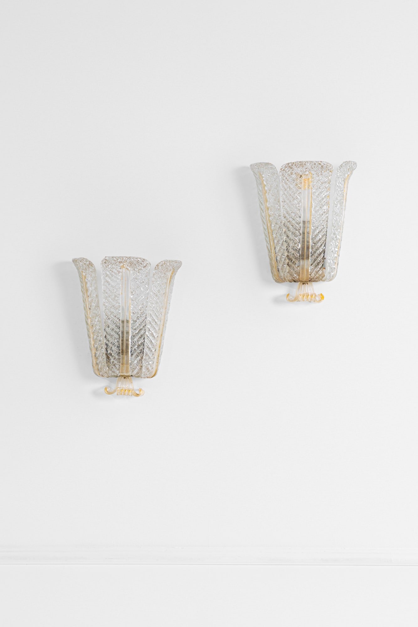 Barovier & Toso. Due lampade da parete: Due lampade da parete Elementi in vetro costolato trasparente e vetro con inclusioni d'oro, metallo verniciato. Prod. Barovier & Toso, 1940 ca. cm 34x27x15