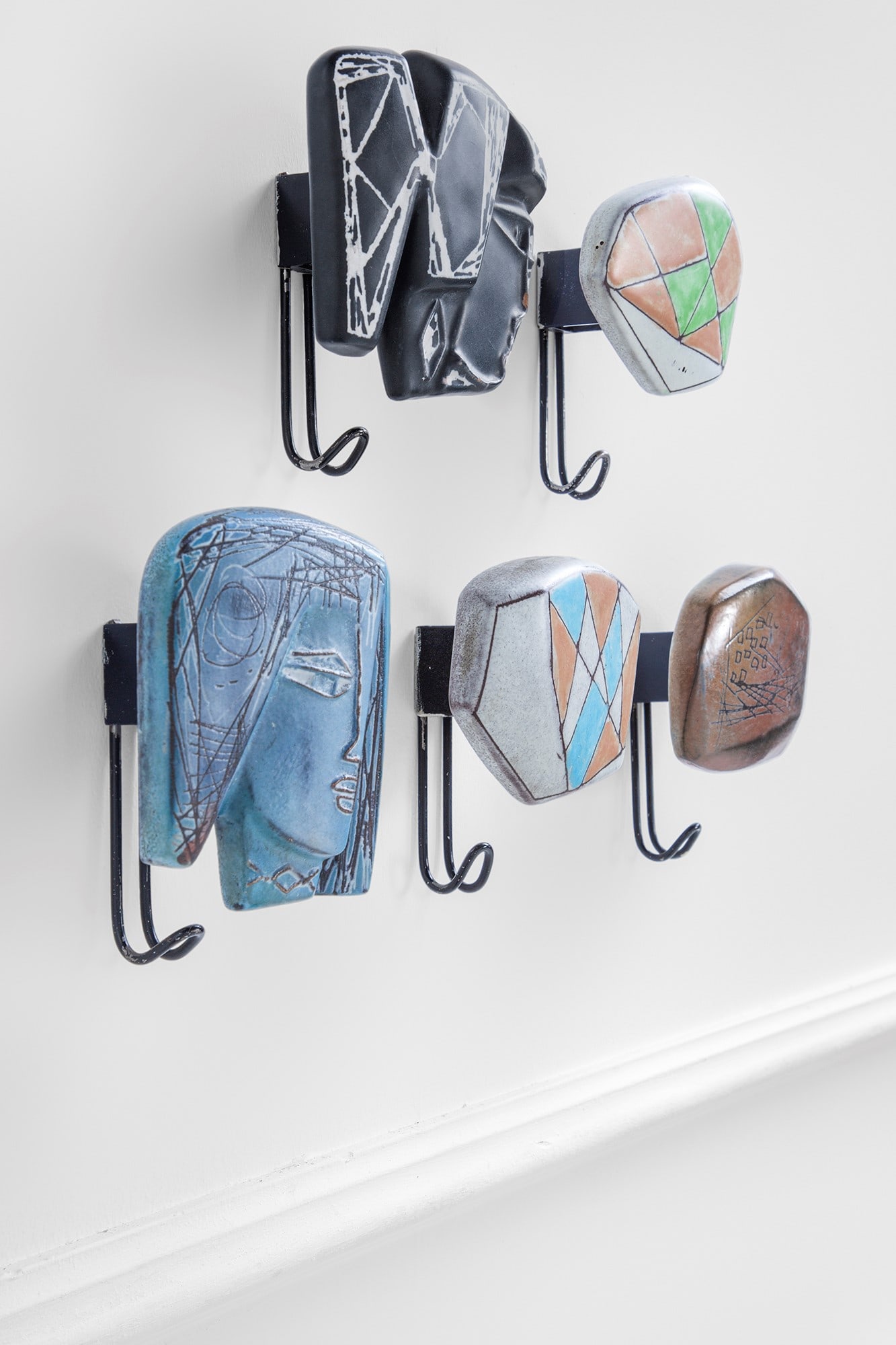 Victor Cerrato. Cinque appendiabiti da parete: Cinque appendiabiti da pareteCeramica smaltata policroma, metallo.Atelier Victor Cerrato, 1960 ca.Impresso sul metallo V. Cerrato Torinocm 16x12x8 (blu), cm 16x14x8 (nero), cm 15x14x8 (marrone), cm