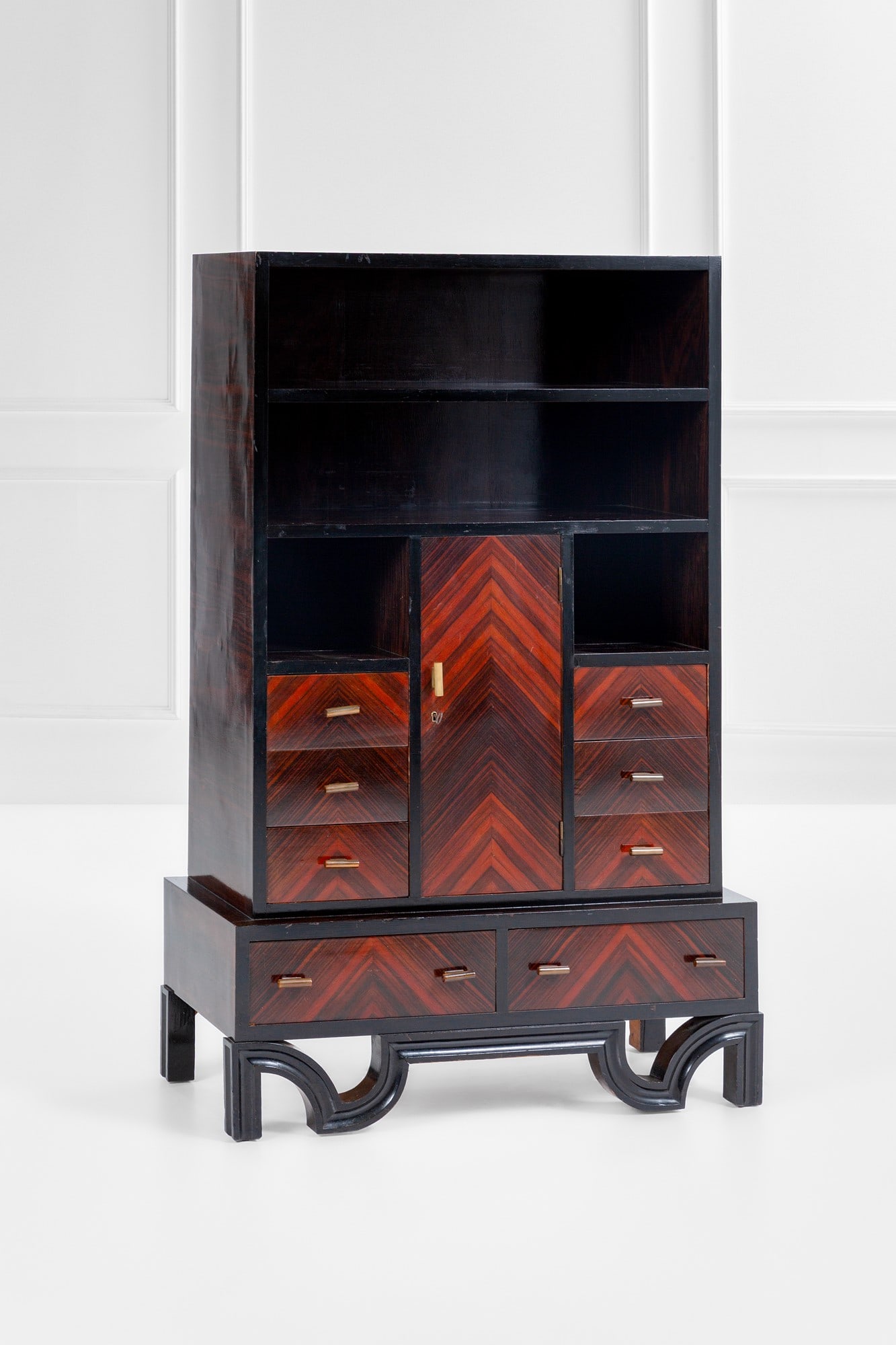 Cabinet con cassetti e alzata con piani a giorno: Cabinet con cassetti e alzata con piani a giorno Legno ebanizzato scanalato, legno impiallacciato, ottone. 1930 ca. cm 171x112x53