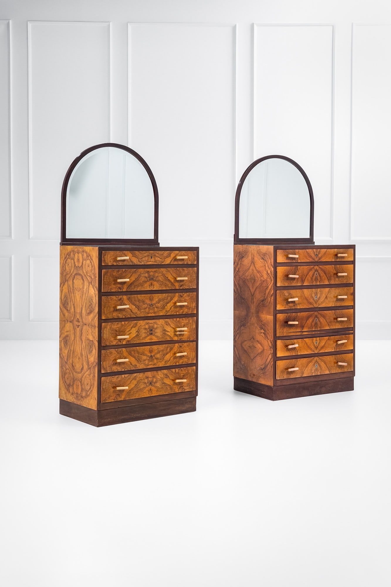 Due settimanali con specchiera: Due settimanali con specchiera Legno tinto, legno impiallacciato in radica, legno massello, cristallo, bachelite, vetro specchiato. 1930 ca. cm 206x90x58