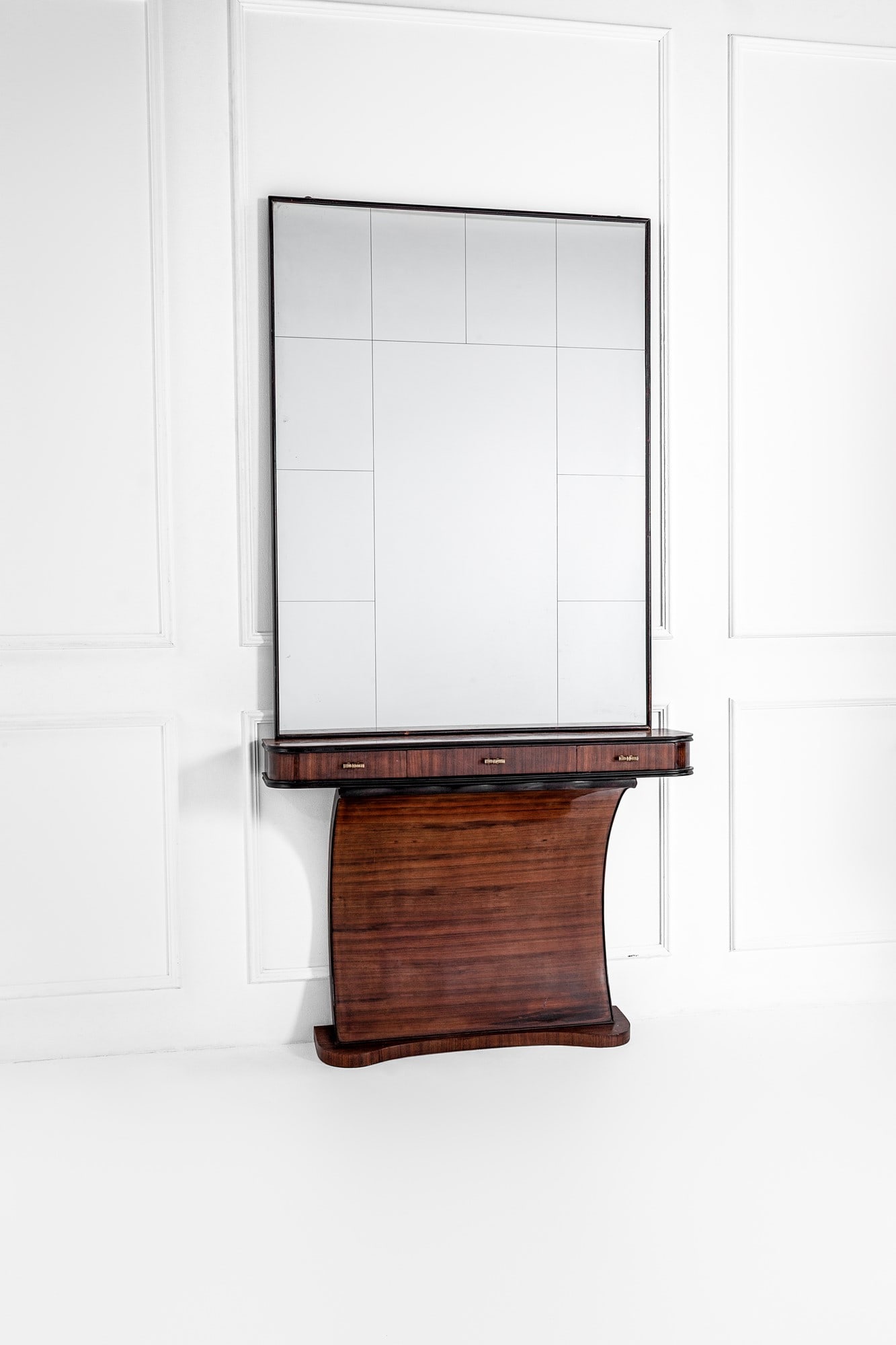 Console a tre cassetti con specchiera: Console a tre cassetti con specchiera Legno impiallacciato, legno ebanizzato, vetro specchiato, ottone. 1940 ca. cm 260x131x32