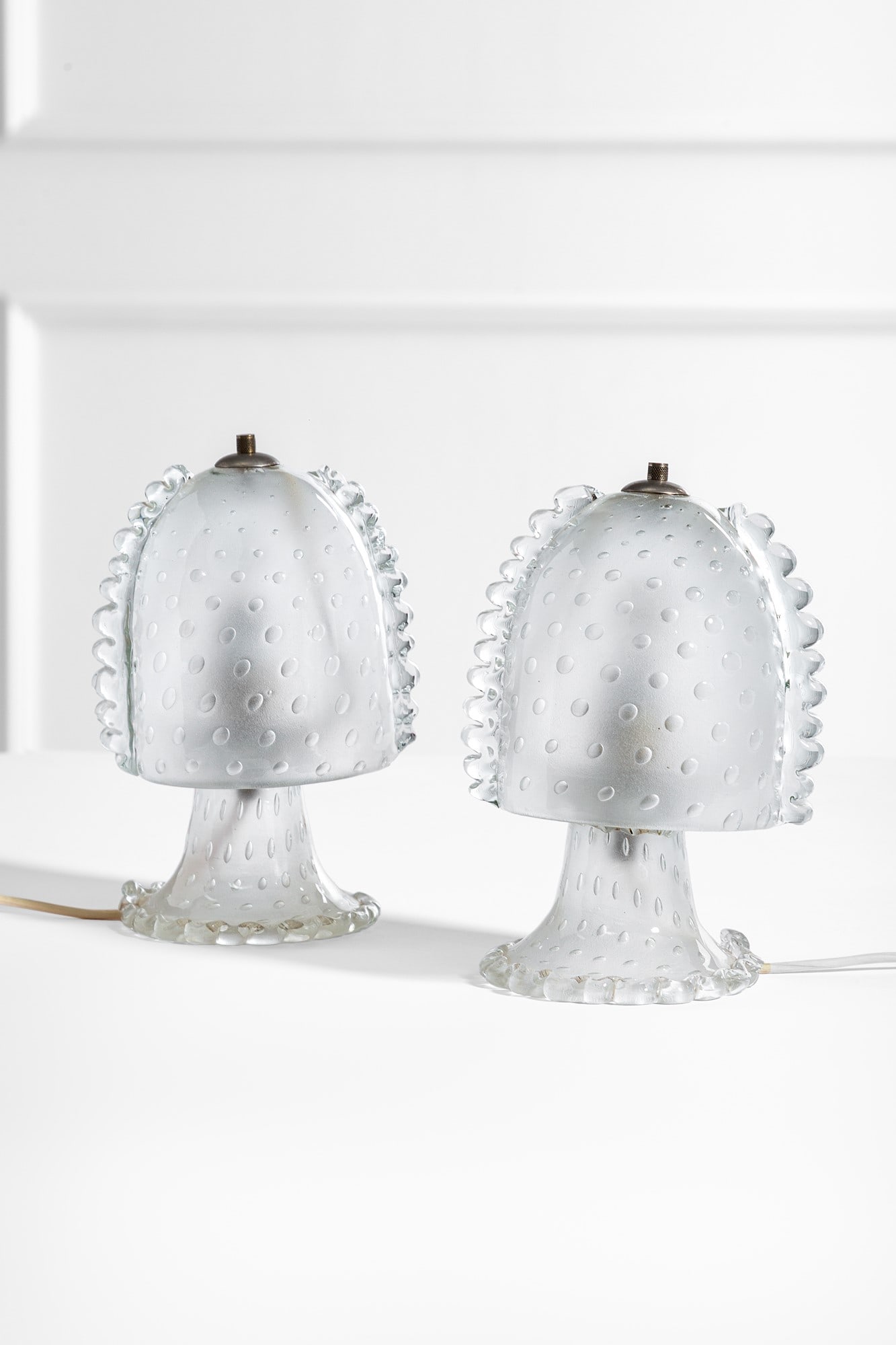 Barovier & Toso. Due lampade da comodino: Due lampade da comodino Vetro pulegoso con inclusione di bolle d'aria, metallo nichelato. Prod. Barovier & Toso, 1930 ca. h cm 23, diam. cm 14