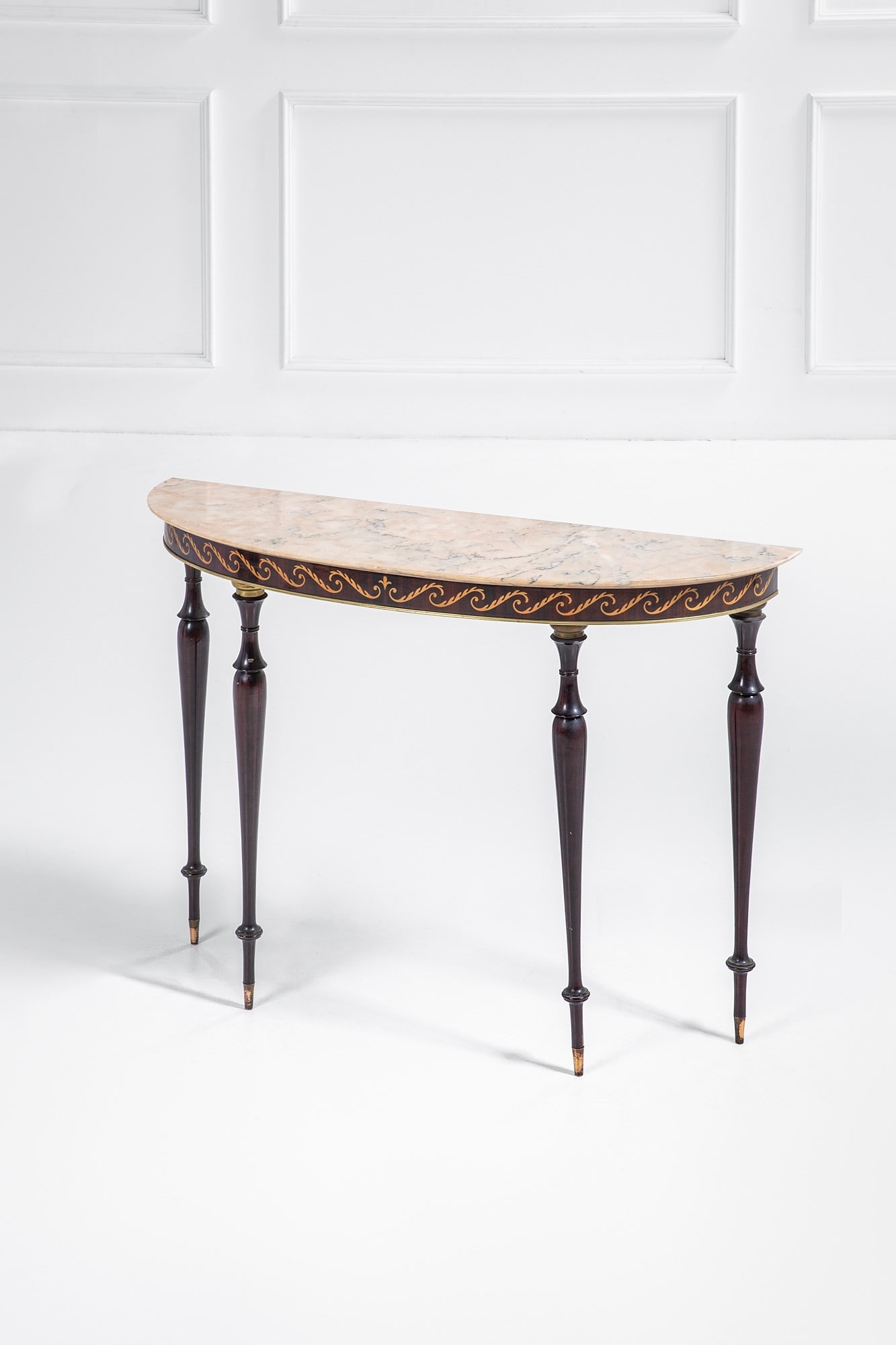 Console a mezzaluna: Console a mezzaluna Legno tornito tinto, legno intarsiato a motivi floreali, marmo, ottone lucido. 1950 ca. cm 84x120x39