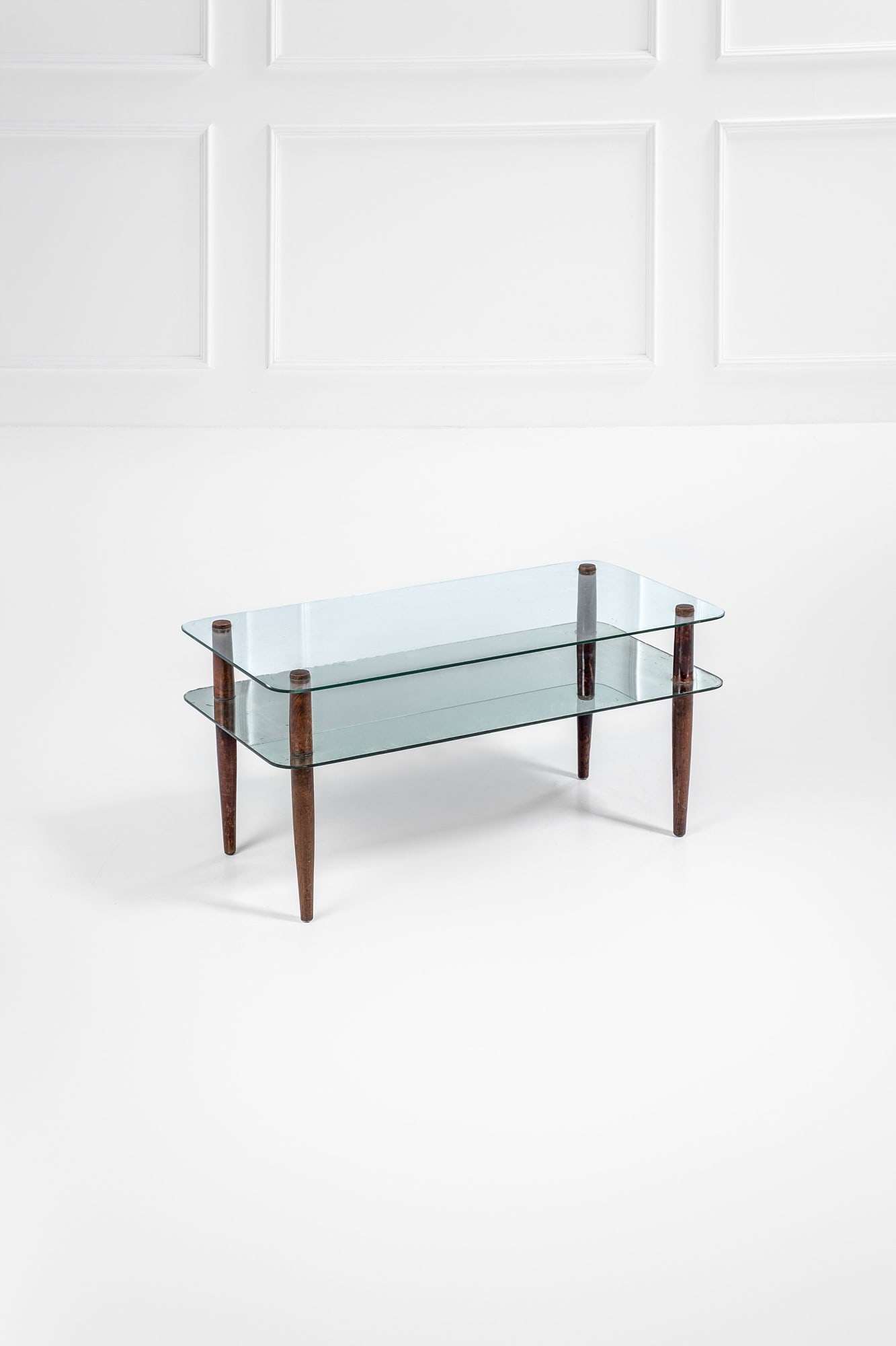 Enrico Paulucci. Tavolino a due ripiani: Tavolino a due ripiani Legno tornito tinto, vetro molato, vetro specchiato. 1950 ca. cm 49x101x51