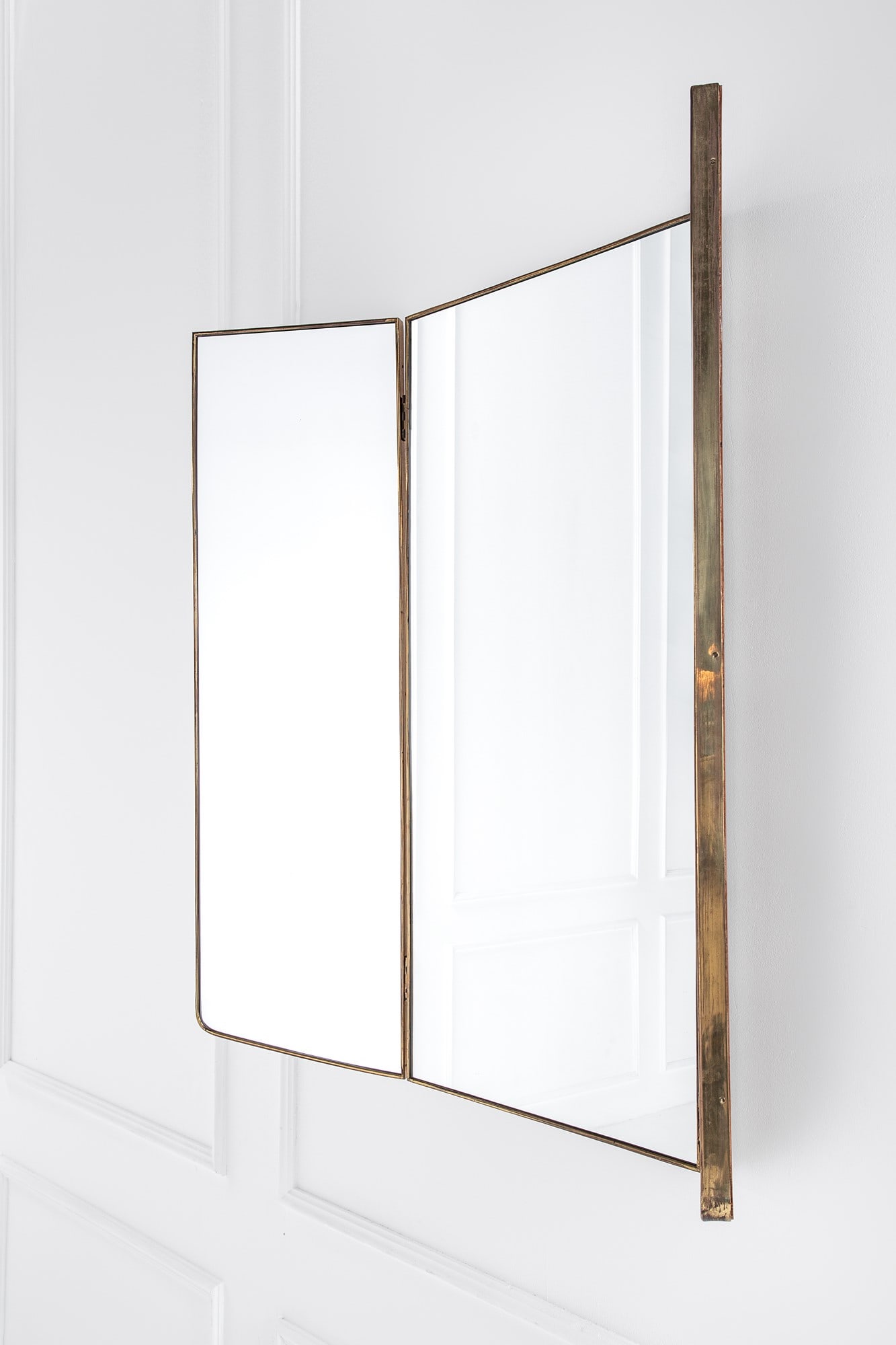 Specchiera a tre ante: Specchiera a tre ante Legno impiallacciato, ottone, vetro specchiato. 1950 ca. cm 125x135x3; chiusa cm 125x45x36