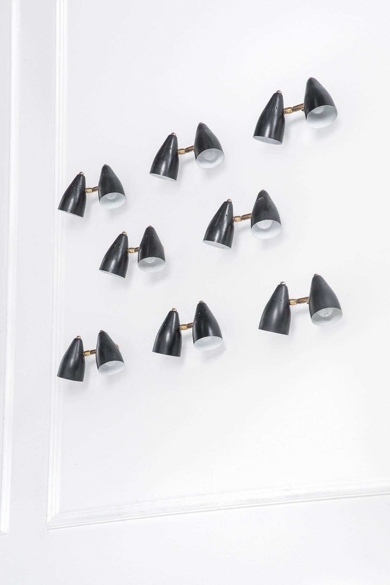 Giuseppe Ostuni (attr.). Otto lampade da parete a due luci orientabili: Otto lampade da parete a due luci orientabili Metallo verniciato, ottone. 1950 ca. cm 12x28x10