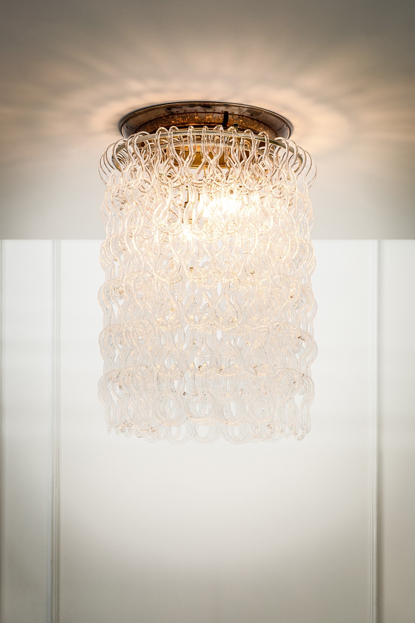 Vistosi. Lampadario: Lampadario Elementi in vetro trasparente collegati da incastro a sospensione, metallo nichelato. Prod. Vistosi, 1970 ca. h cm 82, diam. cm 57