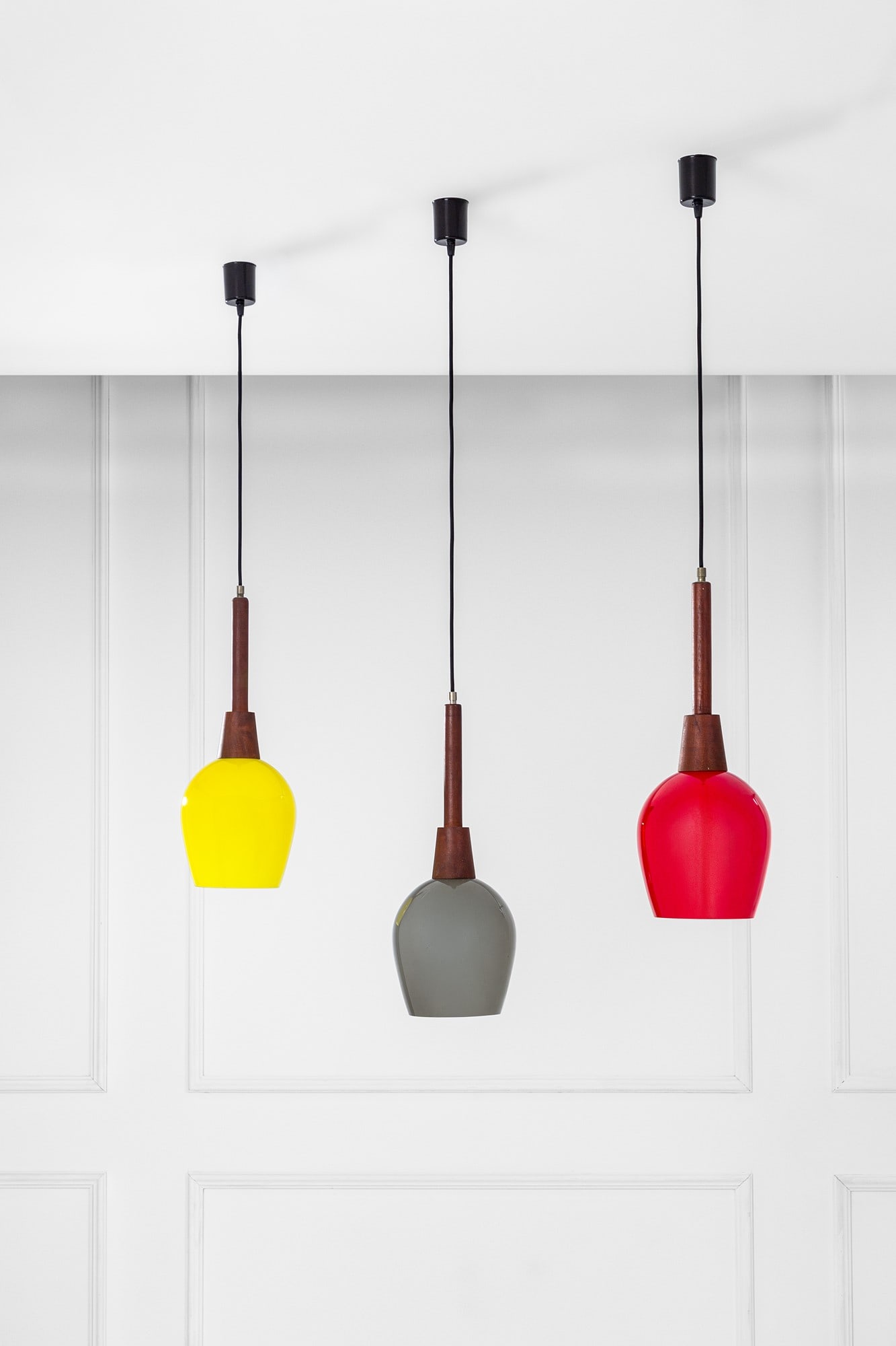 Tre lampade a sospensione: Tre lampade a sospensione Vetro colorato, legno massello, metallo verniciato. 1960 ca. h variabile, pendente h cm 22, diam. cm 18