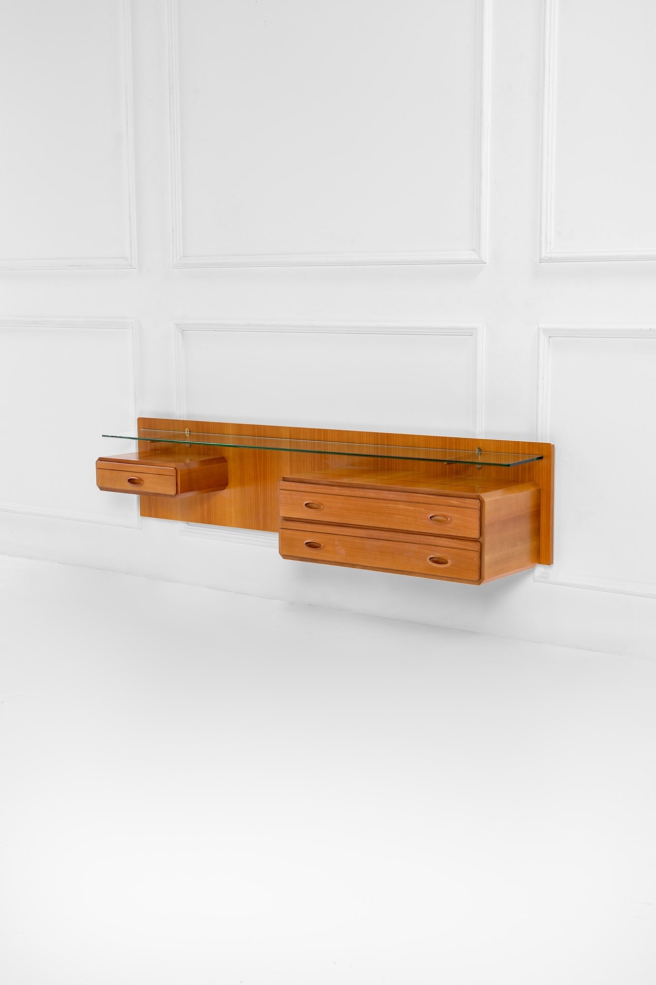 Console pensile con tre cassetti: Console pensile con tre cassetti Legno impiallacciato, legno massello, cristallo molato, ottone. 1960 ca. cm 42x185x41