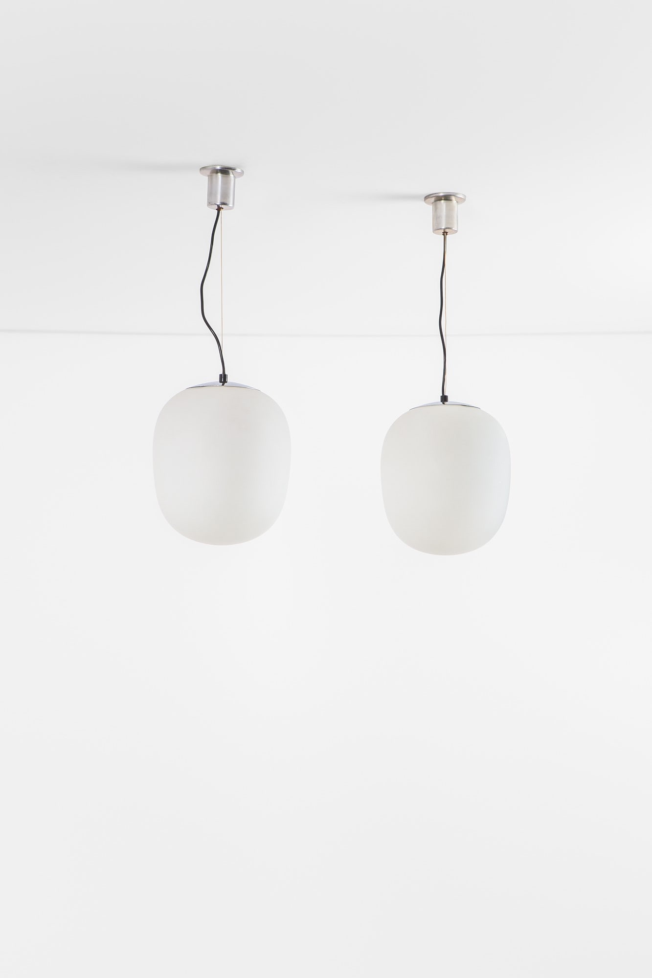 Candle. Quattro lampade a sospensione mod. A4: Quattro lampade a sospensione mod. A4 Metallo cromato, vetro opalino. Prod. Candle, 1960 ca. h cm 70, diam. cm 24 Bibliografia: Candle: illuminazione per l'arredamento, catalogo di produzione.