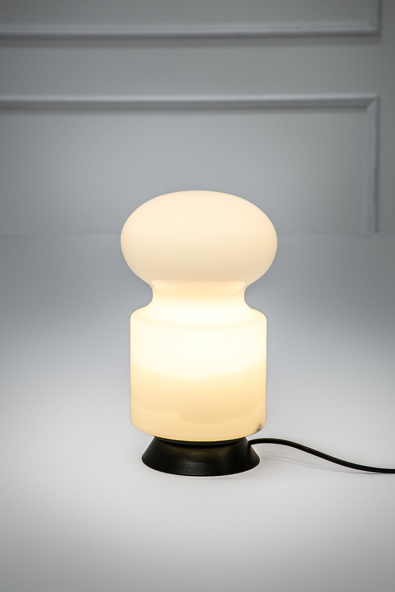 Vistosi. Lampada da tavolo: Lampada da tavolo Vetro soffiato di Murano lattimo, metallo verniciato. Prod. Vistosi, 1970 ca. h cm 28 diam cm 16