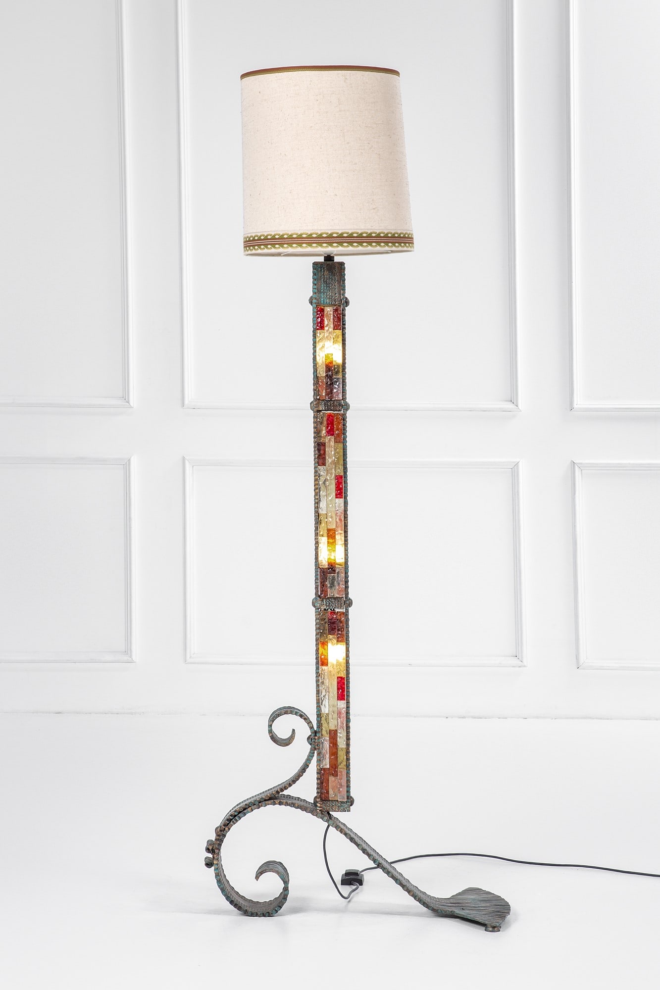 Poliarte (attr.). Lampada da terra: Lampada da terra Metallo martellato e forgiato, elementi in vetro colorato e trasparente lavorati a spacco, tessuto. Prod. Poliarte, 1970 ca. cm 198x40x70