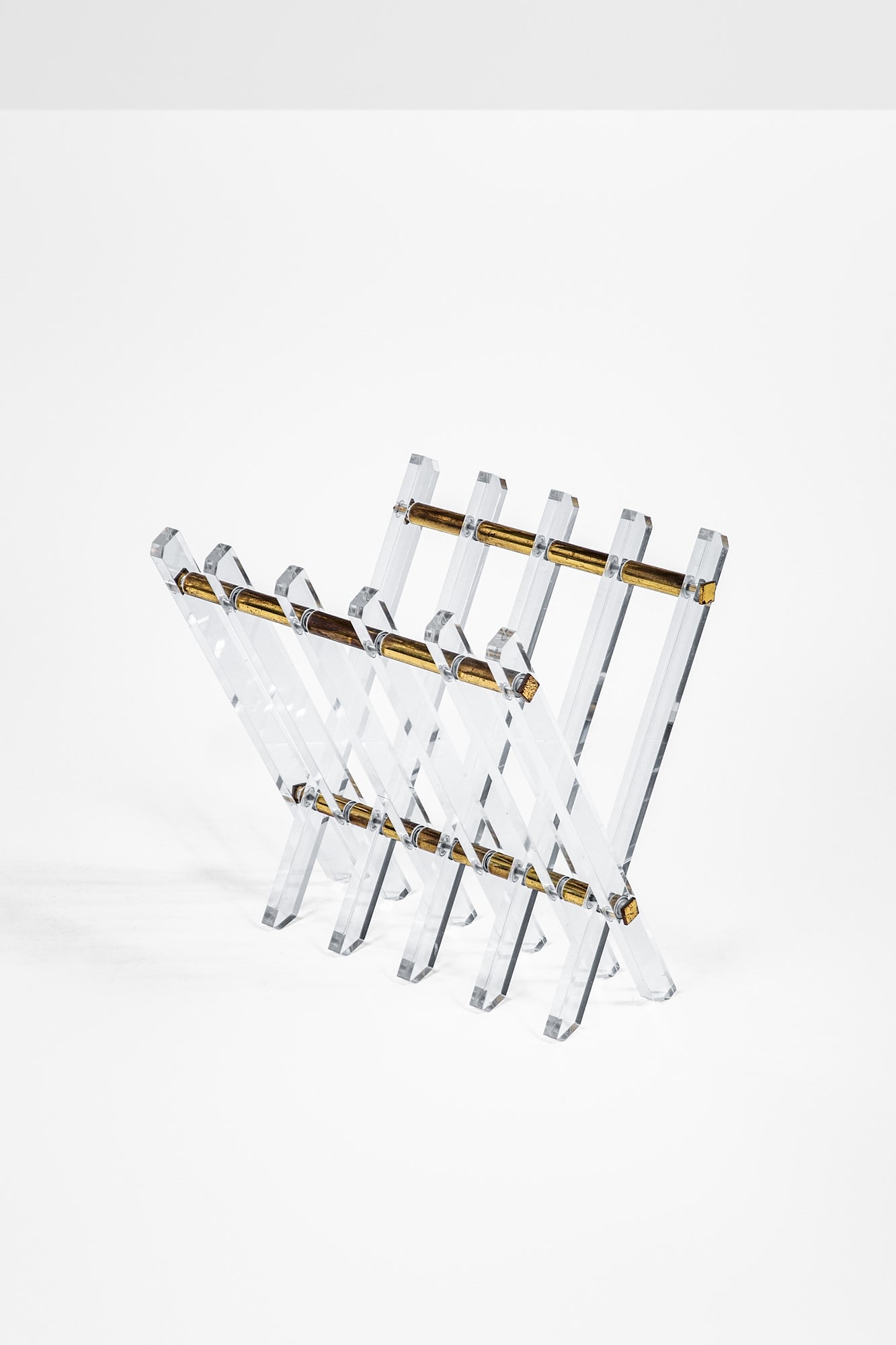 Maison Jansen, nel gusto di. Portariviste: Portariviste Ottone lucido, bacchette in metacrilato trasparente. 1970 ca. cm 35x43x39, chiuso cm 44x6x39
