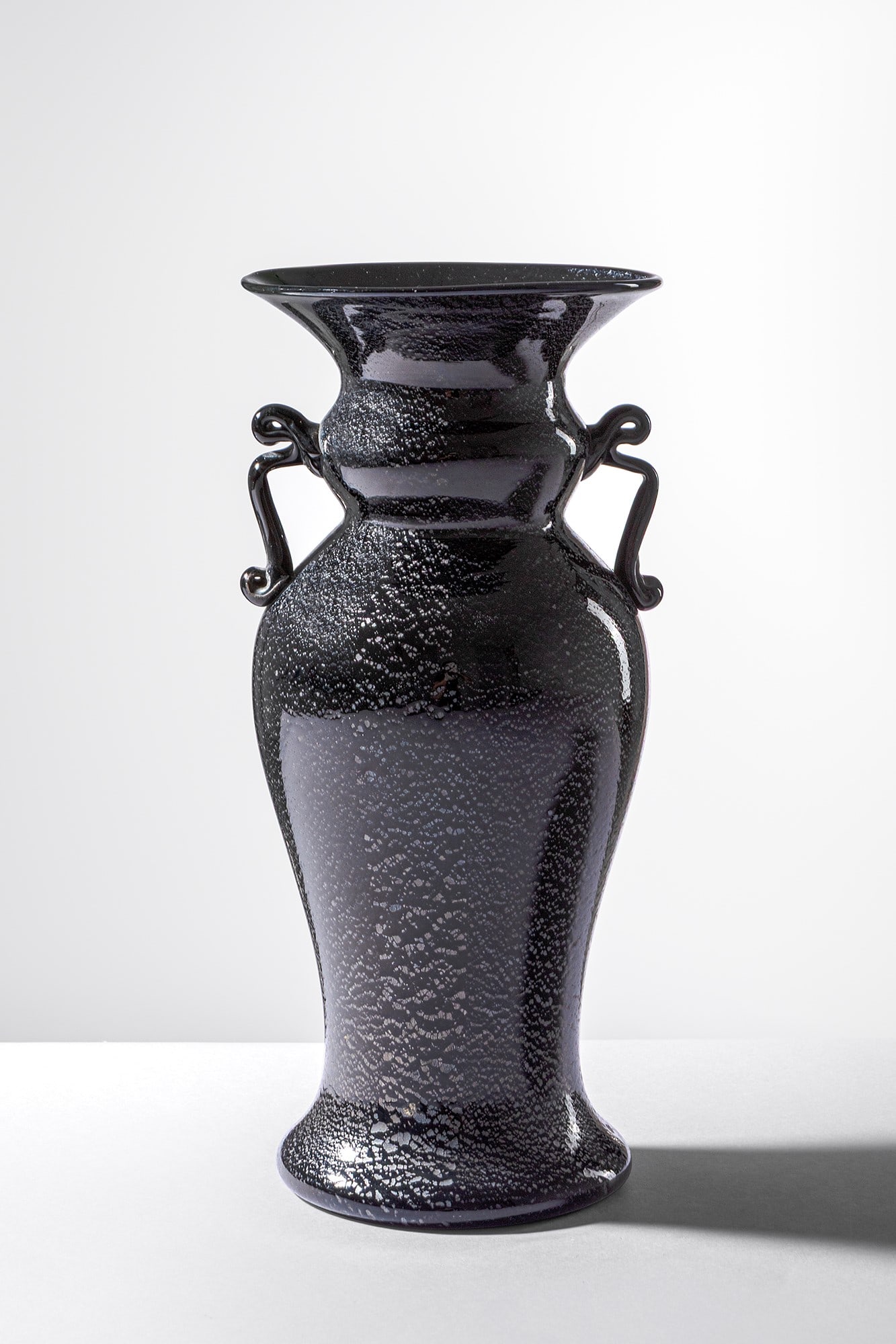 Fratelli Toso. Vaso con anse a nastro: Vaso con anse a nastro Vetro soffiato nero e foglia d’argento ossidata, anse a nastro applicate a caldo. Fratelli Toso, 1925 ca. h cm 27, diam. cm 12