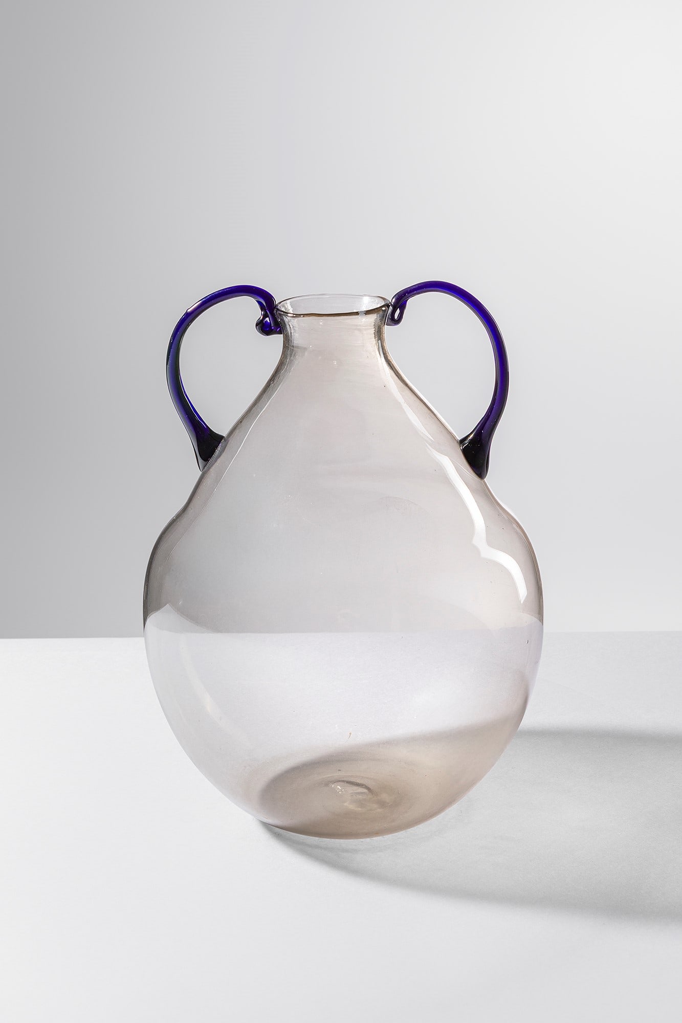 Murano. Vaso biansato: Vaso biansato Vetro soffiato trasparente pagliesco con anse in pasta vitrea nera. Murano, 1920 ca. h cm 23, larg. cm 16