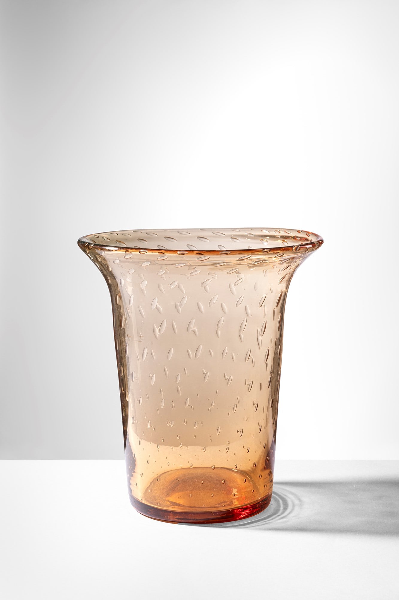 Venini. Vaso: Vaso Vetro soffiato trasparente ambra decorato con bolle regolari. Venini, 1930 ca. Firma all'acido Venini Murano. h cm 22, diam. cm 20