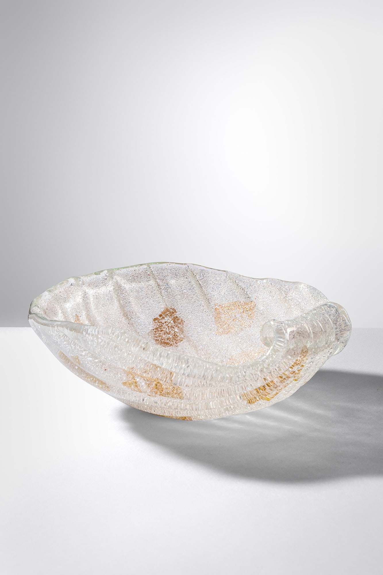 Ercole Barovier. Coppa della serie Rugiadoso: Coppa della serie Rugiadoso Eseguita su piastra con granuli vitrei applicati a caldo su vetro incolore per ottenere l’effetto rugiada. Decorata con foglia d’oro. Barovier & Toso, 1940 ca. Questa
