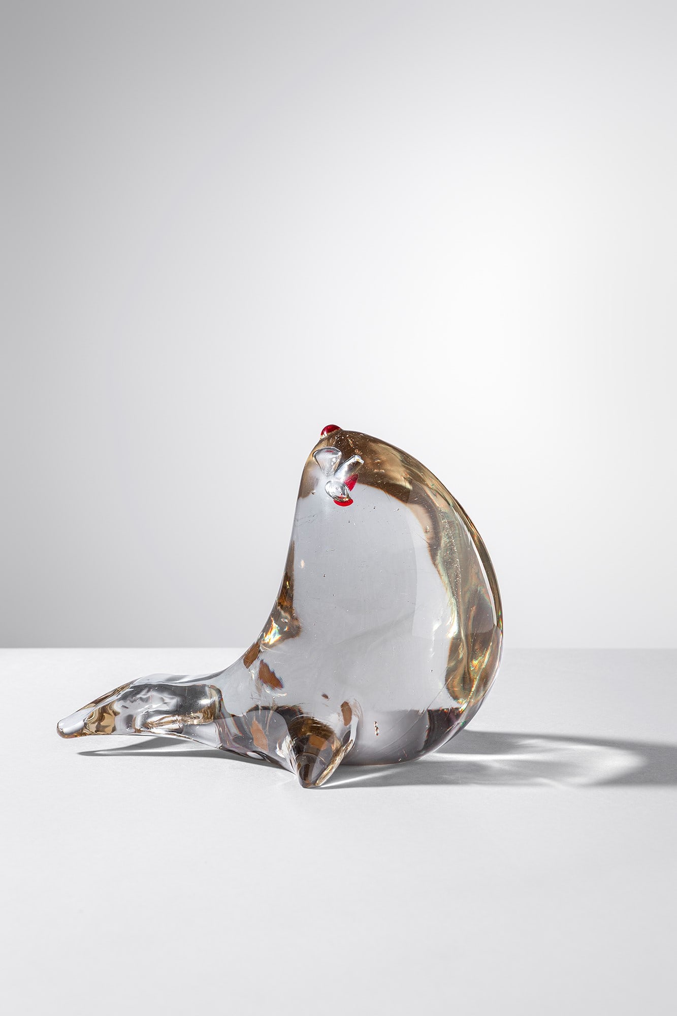 Antonio Da Ros. Scultura a guisa di foca: Scultura a guisa di foca Vetro massiccio grigio con particolari in vetro rosso. Cenedese, 1960 ca. Etichetta parziale del produttore. cm 12x15x11