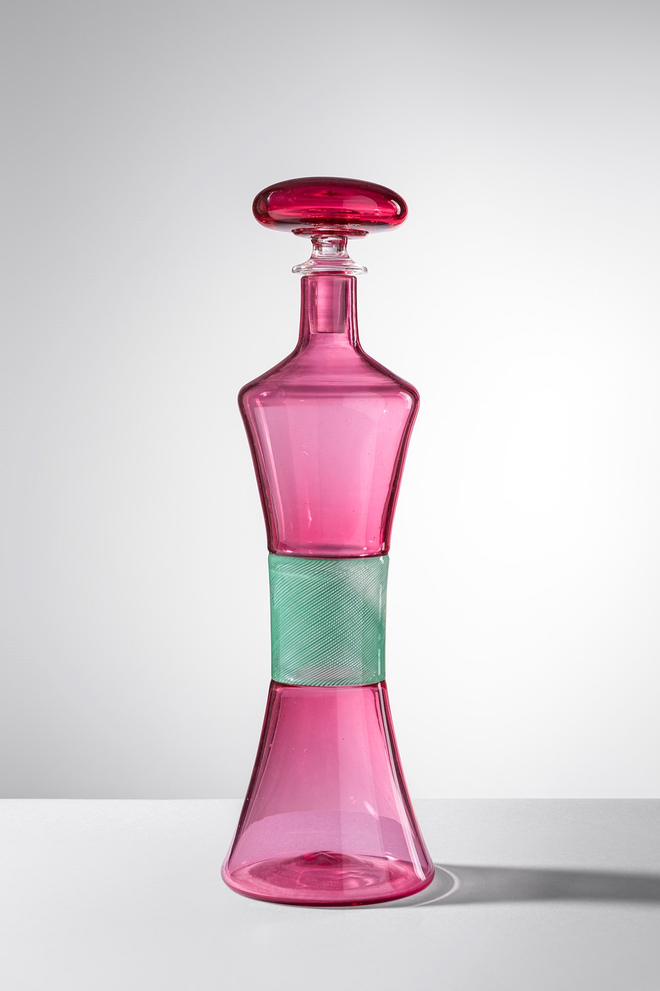 Venini. Bottiglia modello 4747: Bottiglia modello 4747 Vetro soffiato rosa con fascia centrale in vetro a filigrana verde unito ad incalmo. Un esemplare simile venne esposto alla XXX Biennale di Venezia. Venini, 1959. Firma all'acid