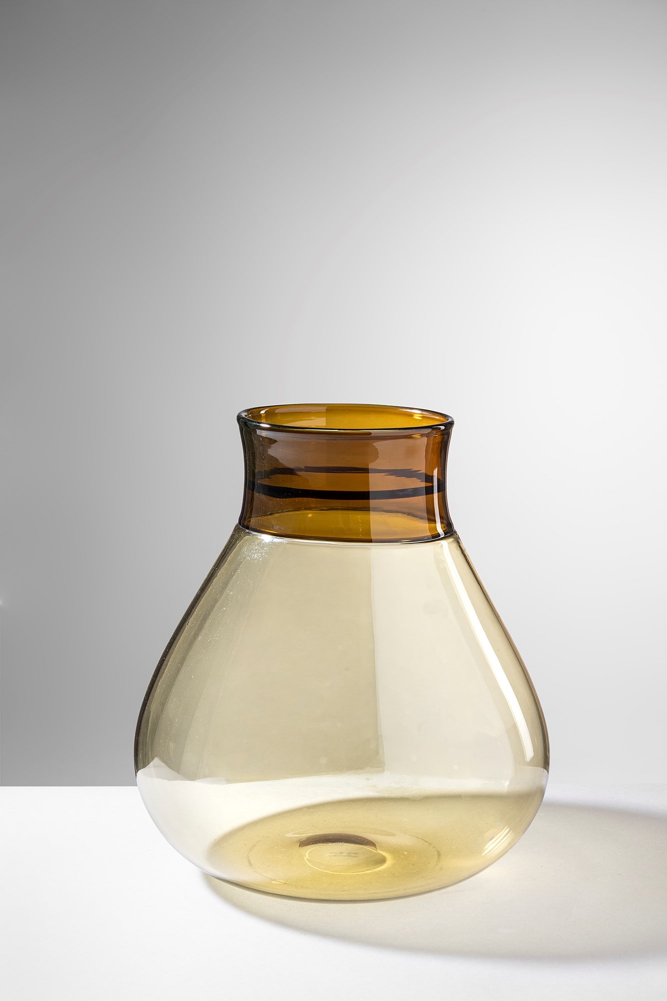 Ludovico Diaz de Santillana. Vaso della serie Colletti: Vaso della serie Colletti Vetro soffiato ambra con collo incalmato di differente colore. Venini & C., 1961. Firma incisa a punta Venini Italia. h cm 28, larg. cm 25 Bibliografia: Alessandro Bettagno