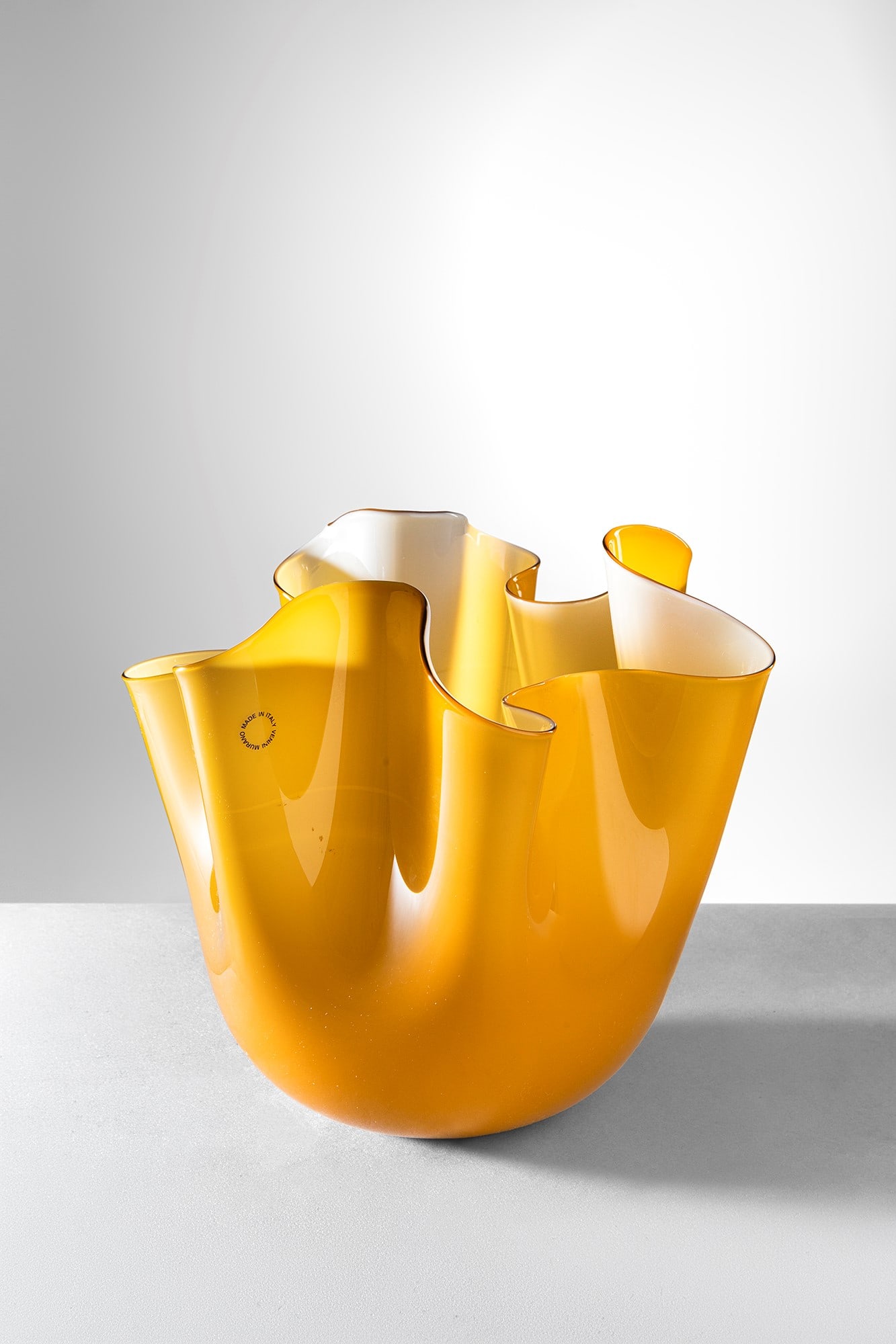 Fulvio Bianconi - Paolo Venini. Fazzoletto mod. 3924: Fazzoletto mod. 3924 Vetro soffiato incamiciato ambra e lattimo. Venini, 2001. Firma incisa a punta Venini 2001. h cm 21, larg. cm 23 Bibliografia: Marino Barovier e Carla Sonego (a cura di), Fulvio