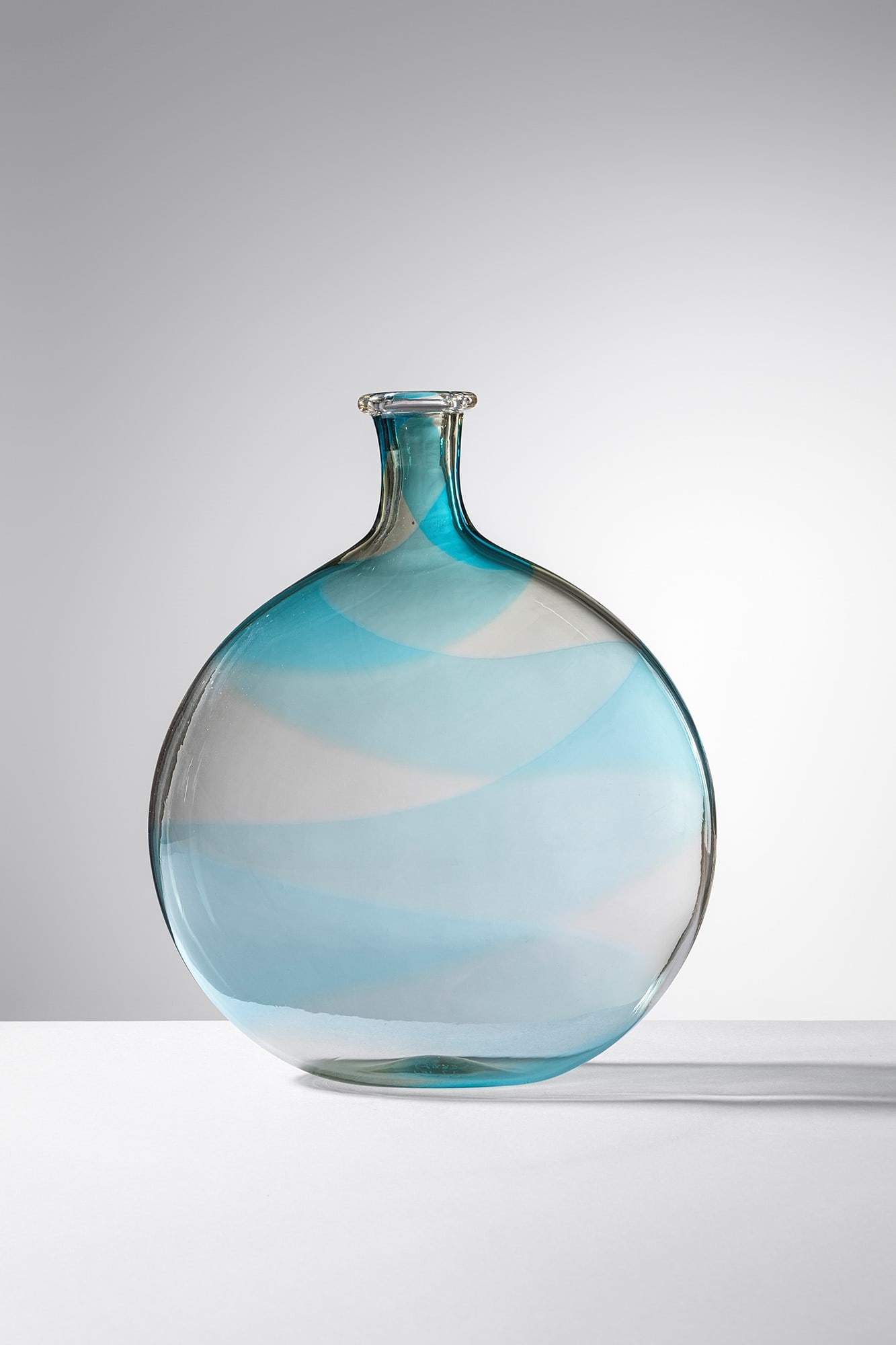 Lino Tagliapietra. Vaso della serie Ghebo: Vaso della serie Ghebo Vetro soffiato trasparente con decoro di larga fascia turchese a spirale. Effetre International, 1983 ca. Firma incisa a punta F3I L.T. 1983. Etichetta del produttore. cm