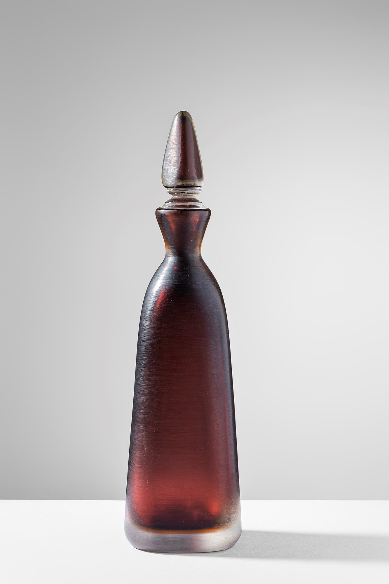 Paolo Venini. Bottiglia della serie Incisi: Bottiglia della serie Incisi Vetro sommerso marrone con superficie incisa da venature molto sottili. Disegno del 1956-57. Venini, 1992. Firma incisa a punta Venini 92. cm 39x9x9 Bibliografia: Marino