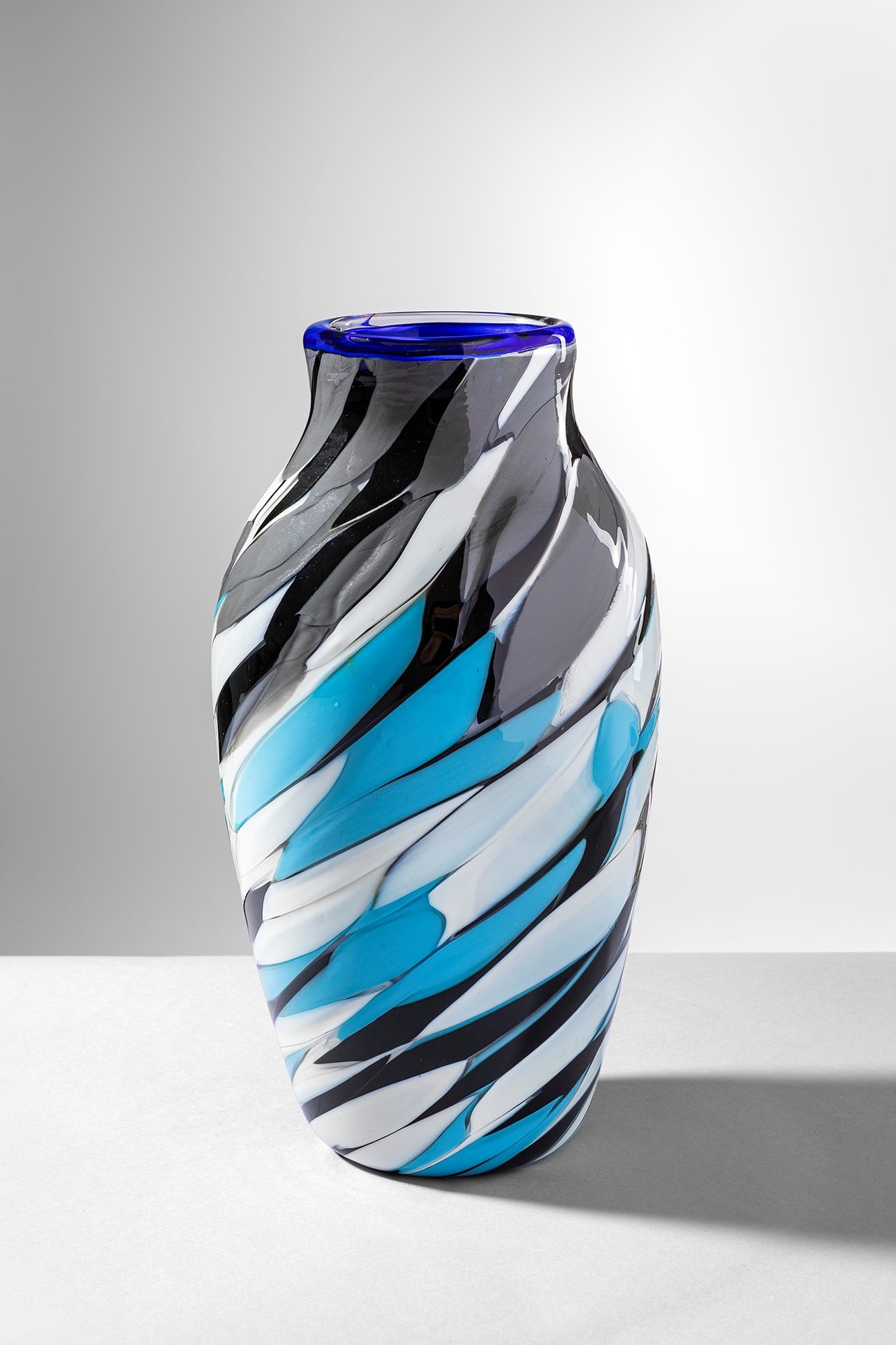 Vittorio Ferro. Vaso Piume: Vaso Piume Vetro soffiato cristallo, con applicazioni di fasce in pasta colorata, nei colori avorio, verde e nero. de Majo, 1990 ca. Firma incisa a punta Vittorio Ferro P.d.A. h cm 29, larg. cm 15