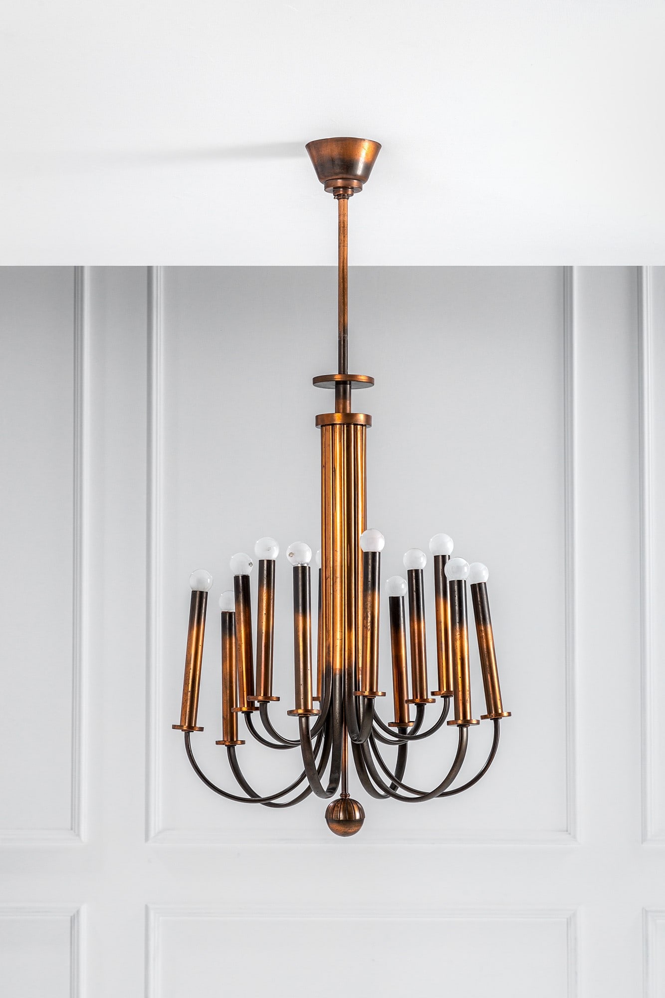 Art Deco'. Grande lampadario a dodici luci: Grande lampadario a dodici luci Metallo con finitura in rame, metallo brunito. 1930 ca. cm 124x60x50