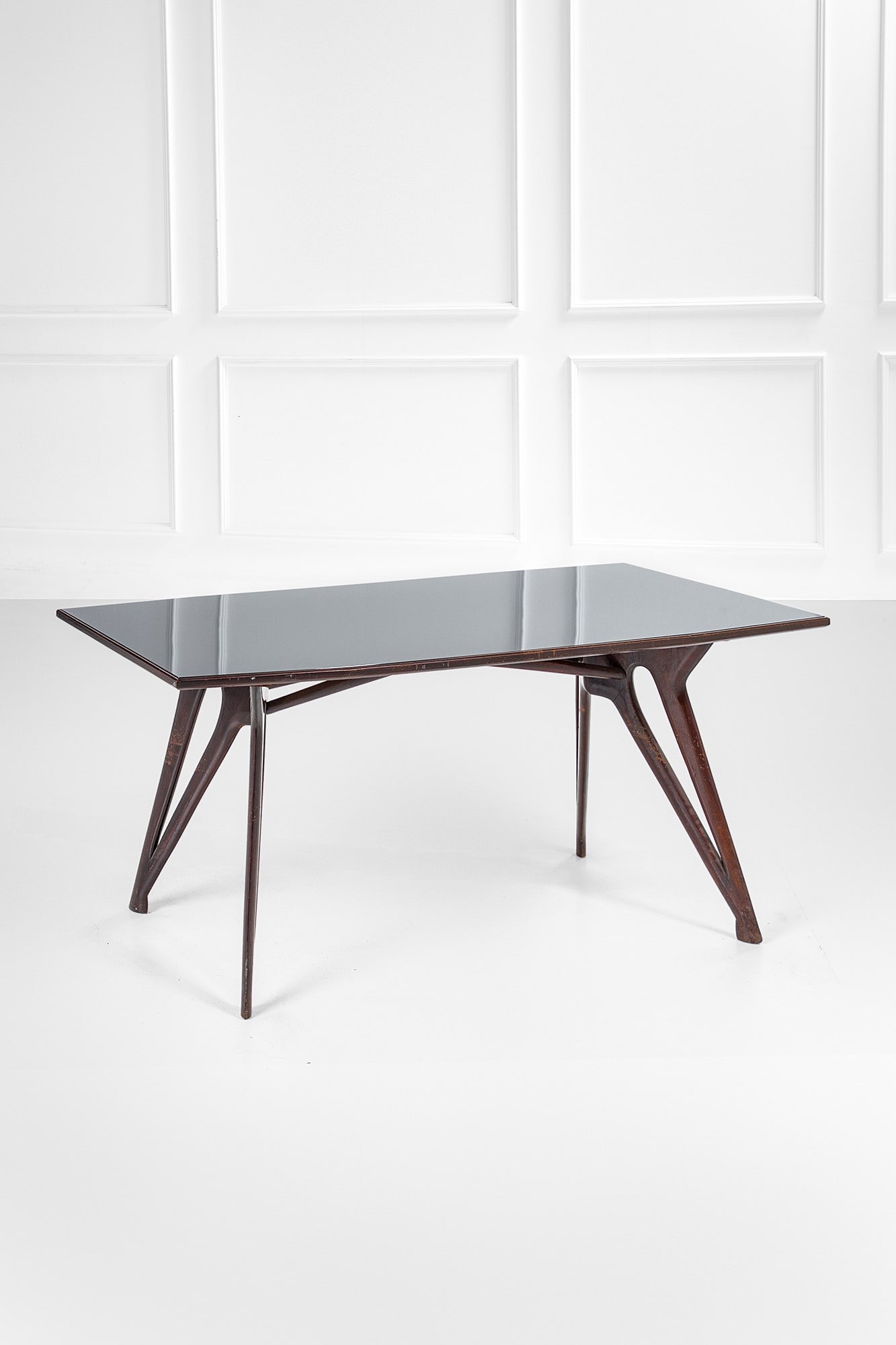 Tavolo: Tavolo Legno massello tinto sagomato, vetro colorato. 1950 ca. cm 77x172x82