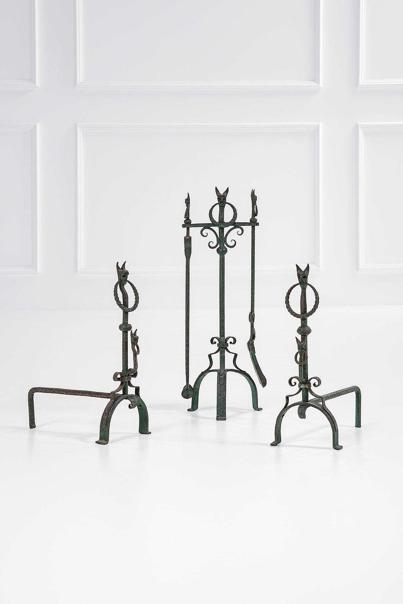 Set da camino formato da due alari e attrezzi: Set da camino formato da due alari e attrezzi Ferro battuto e sagomato con figure antropomorfe. 1950 ca. Alari cm 44x36x18; porta atrezzi cm 63x21x20; paletta cm 55x11x3; pinza cm 56x11x3