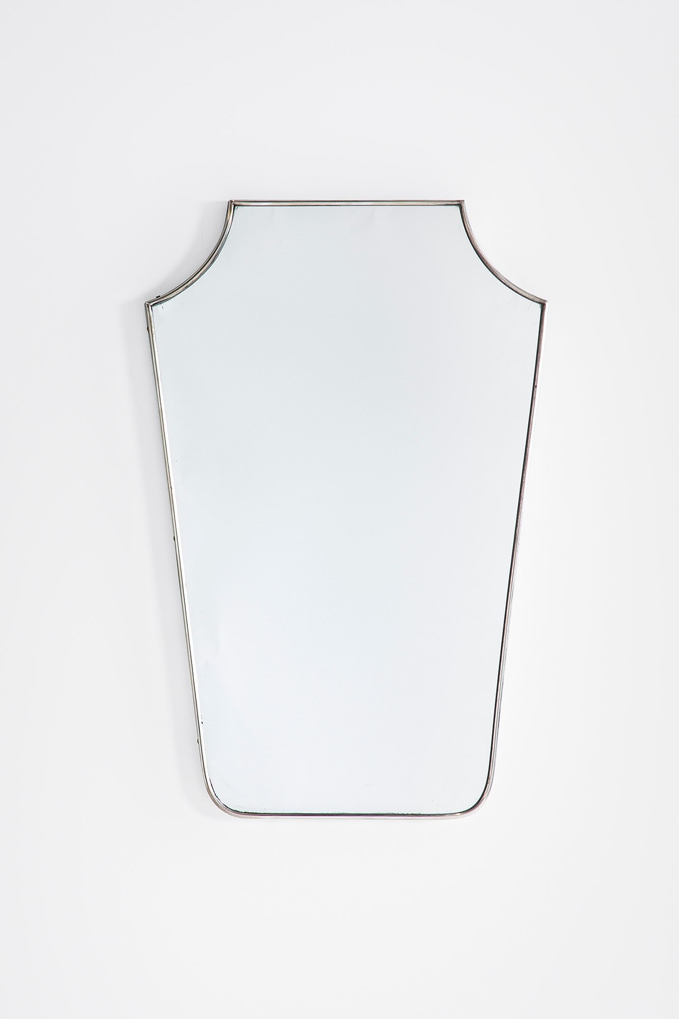 Specchio da parete a scudo: Specchio da parete a scudo Metallo nichelato, vetro specchiato. 1950 ca. cm 74x48x3