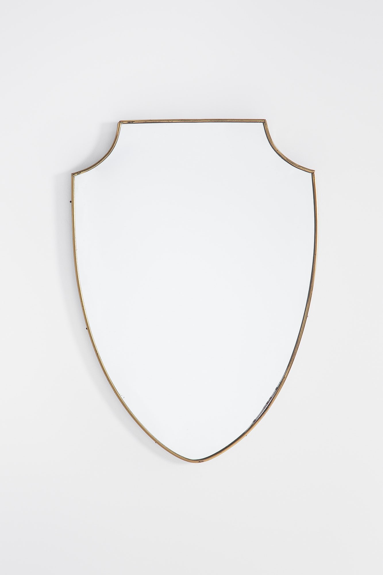 Specchio da parete a scudo: Specchio da parete a scudo Ottone lucido, vetro specchiato. 1950 ca. cm70x49x3