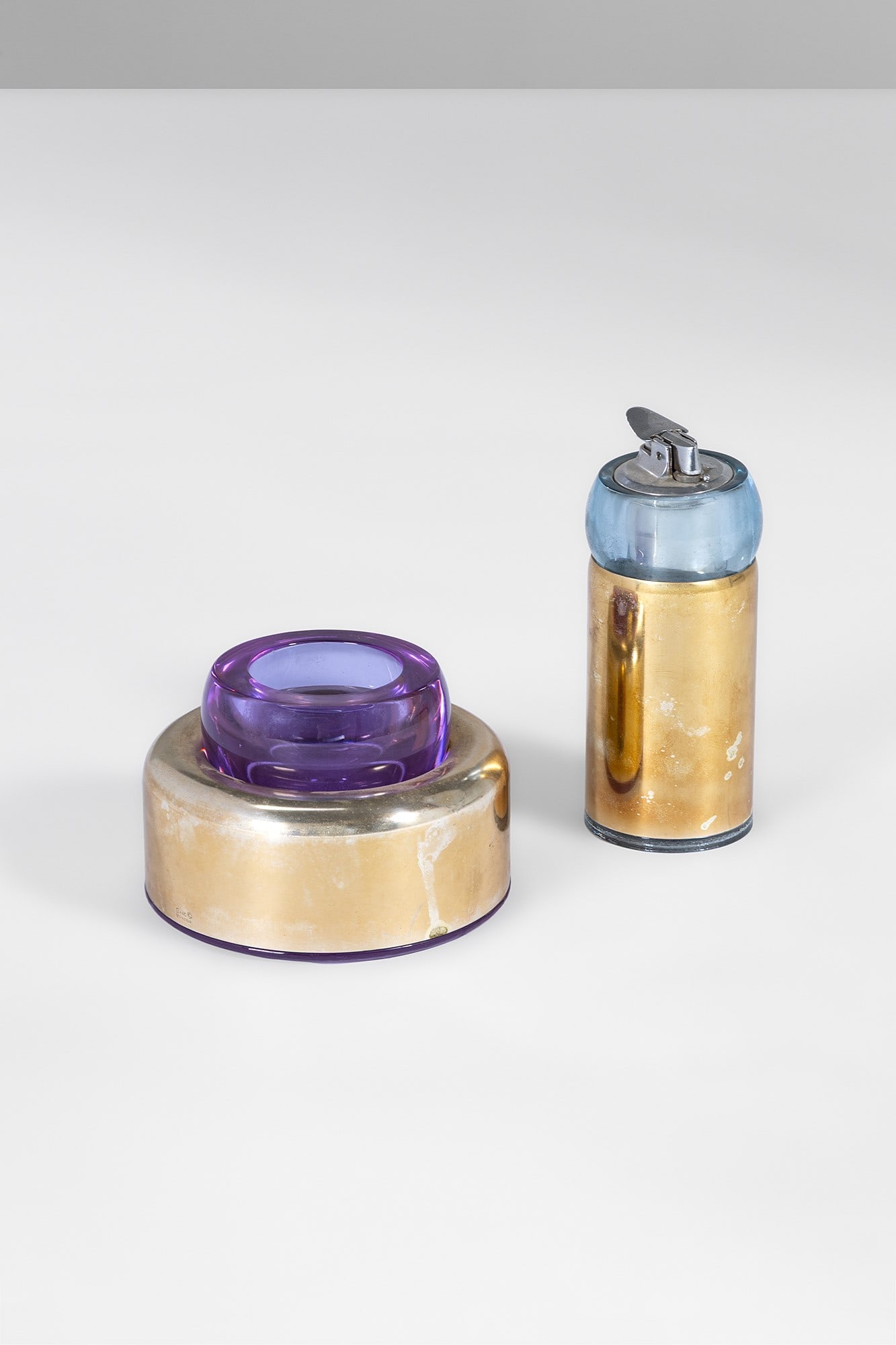 Joe Colombo. Set da fumo: Set da fumo Vetro colorato, metallo placcato argento. Prod. Arnolfo di Cambio, 1970 ca. Etichetta del produttore. Portasigarette h cm 15, diam. cm 7; accendino h cm 15, diam. cm 17