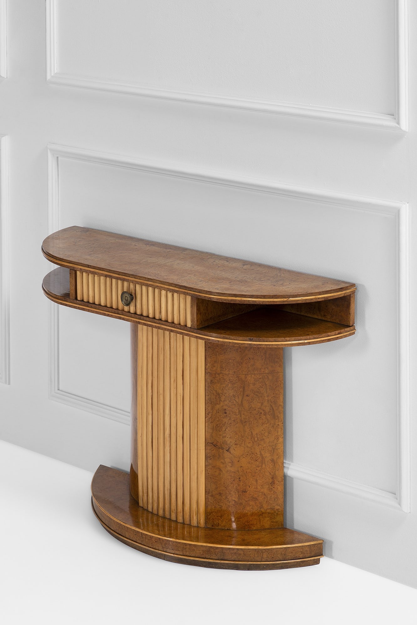Console a mezzaluna con cassetto: Console a mezzaluna con cassetto Legno massello, legno impiallacciato in radica, legno grissinato, ottone. 1940 ca. cm 82x110x35